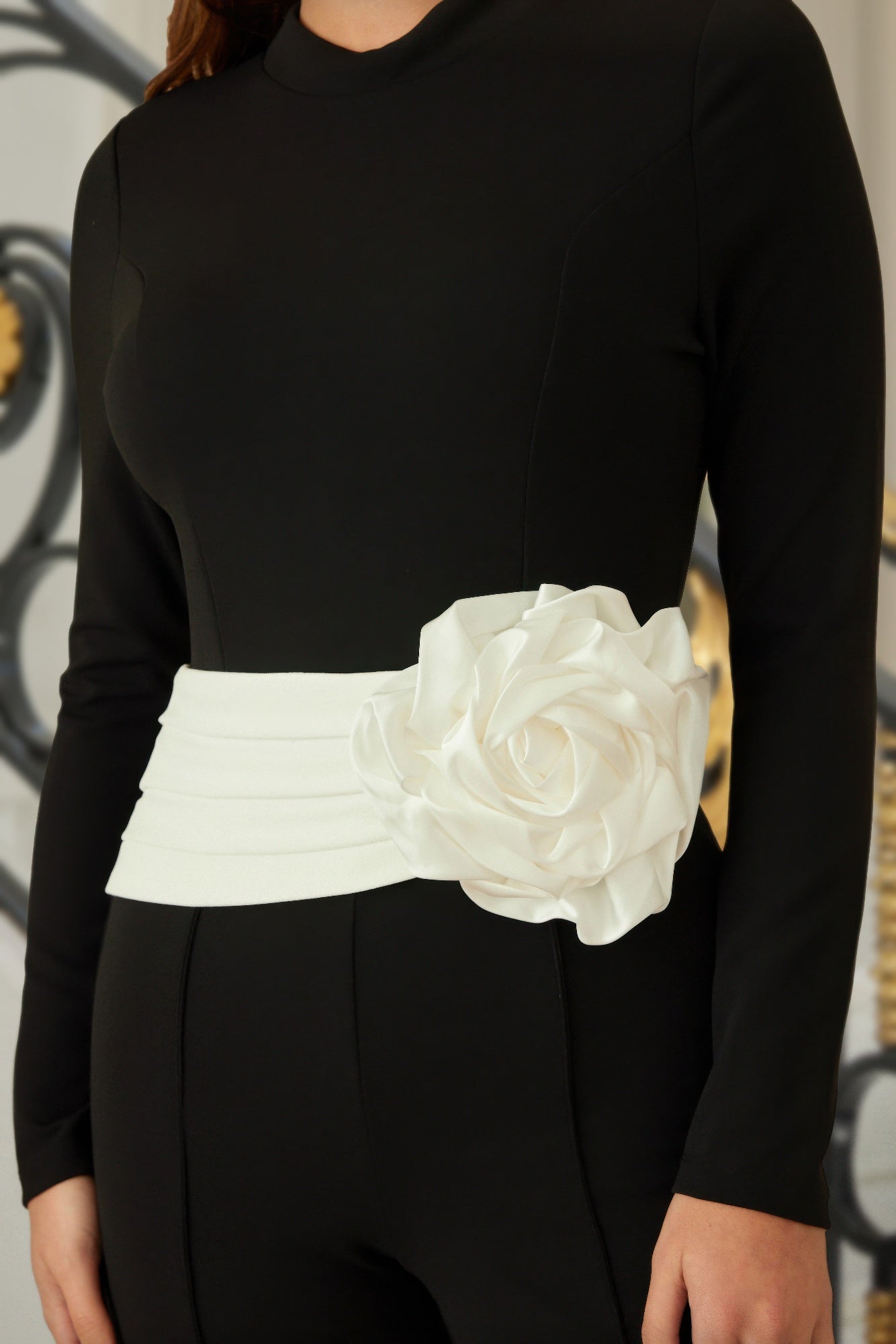 White rose applique on wide waistband of black jumpsuit