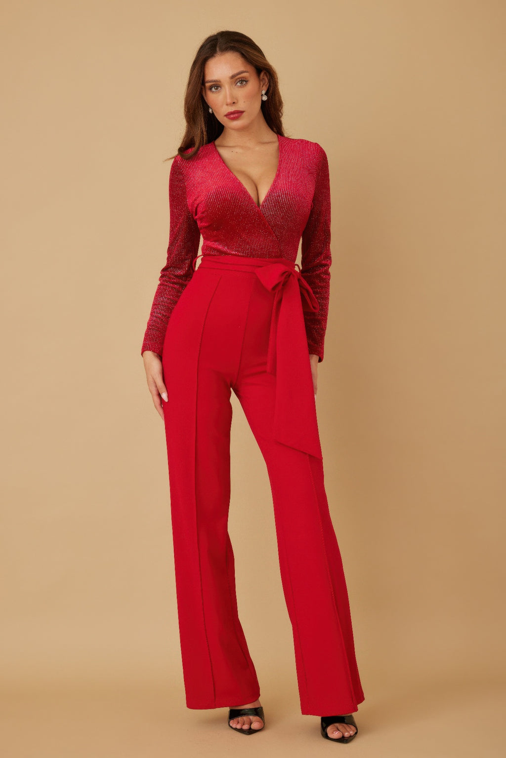 Red velvet top jumpsuit with deep V-neck, long sleeves, and tied waist belt