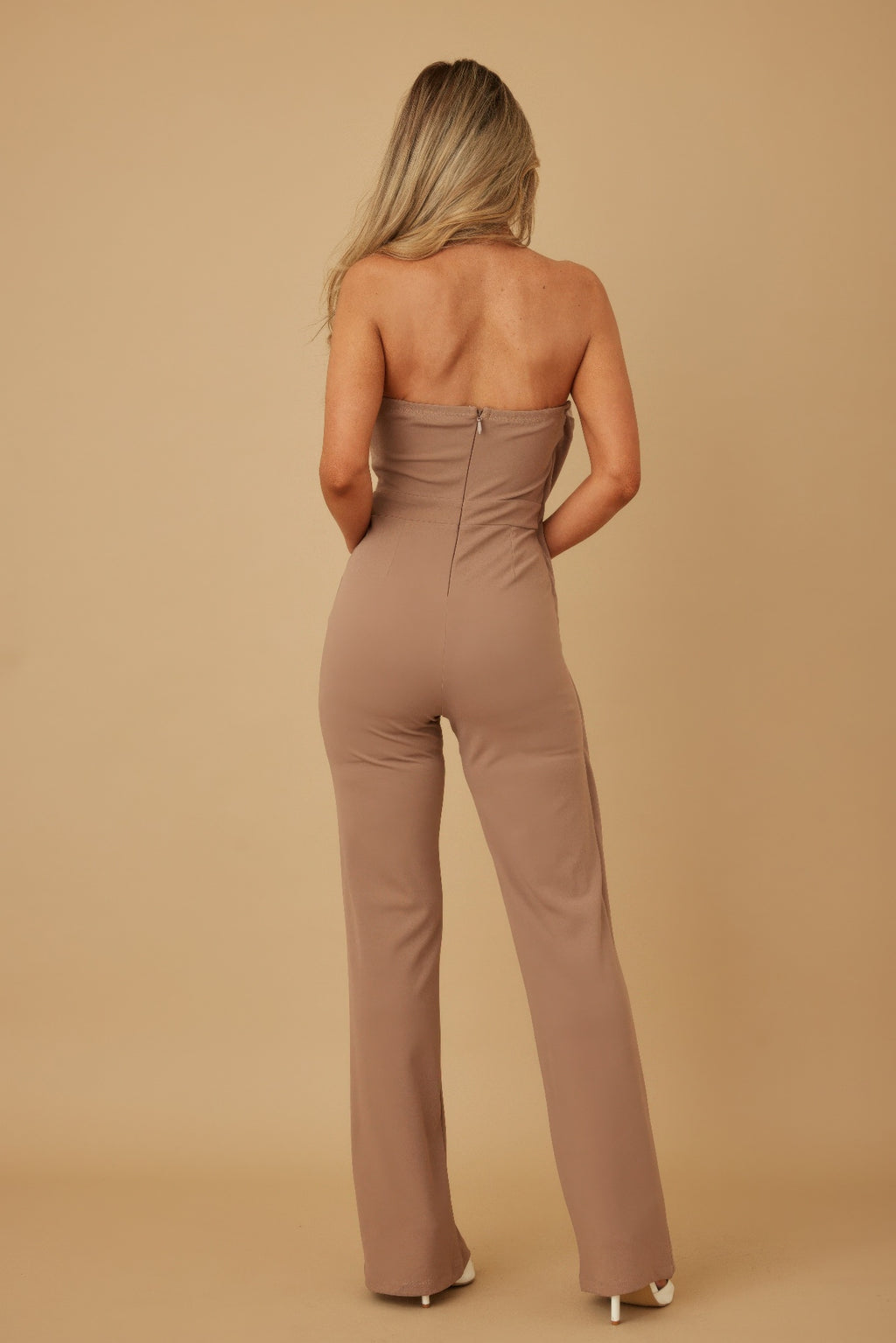 Back view taupe strapless jumpsuit, gathered waist and wide-leg flare