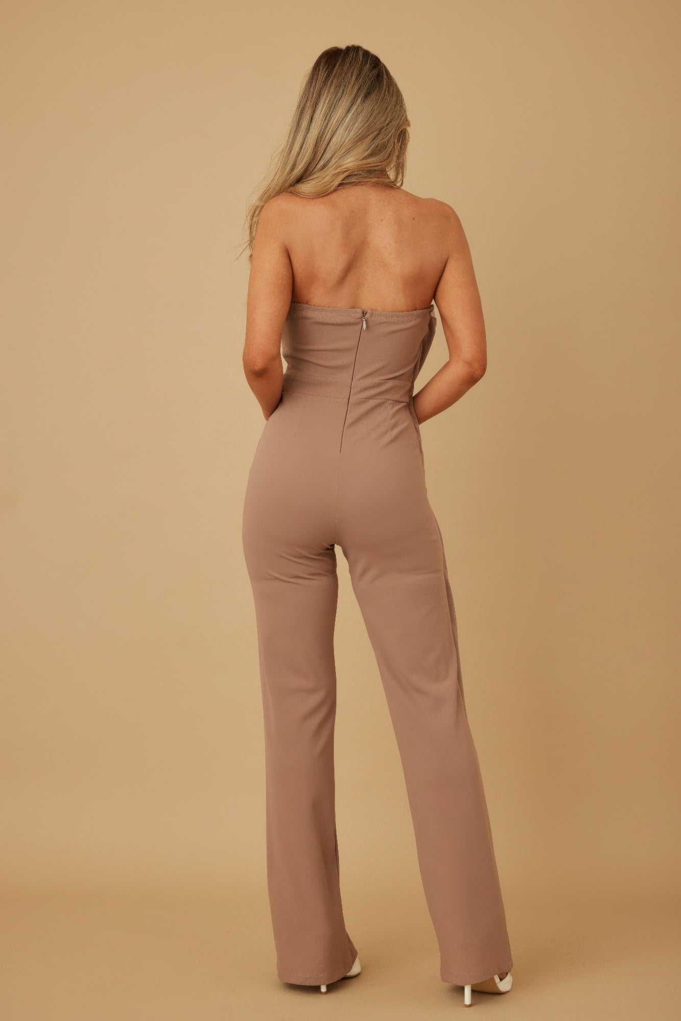 Back view taupe strapless jumpsuit, gathered waist and wide-leg flare
