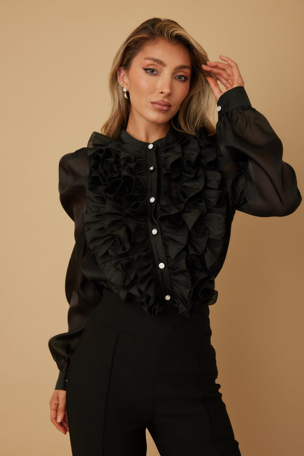 Black long-sleeve blouse with puff sleeves and layered ruffle bib; silver-tone button front.
