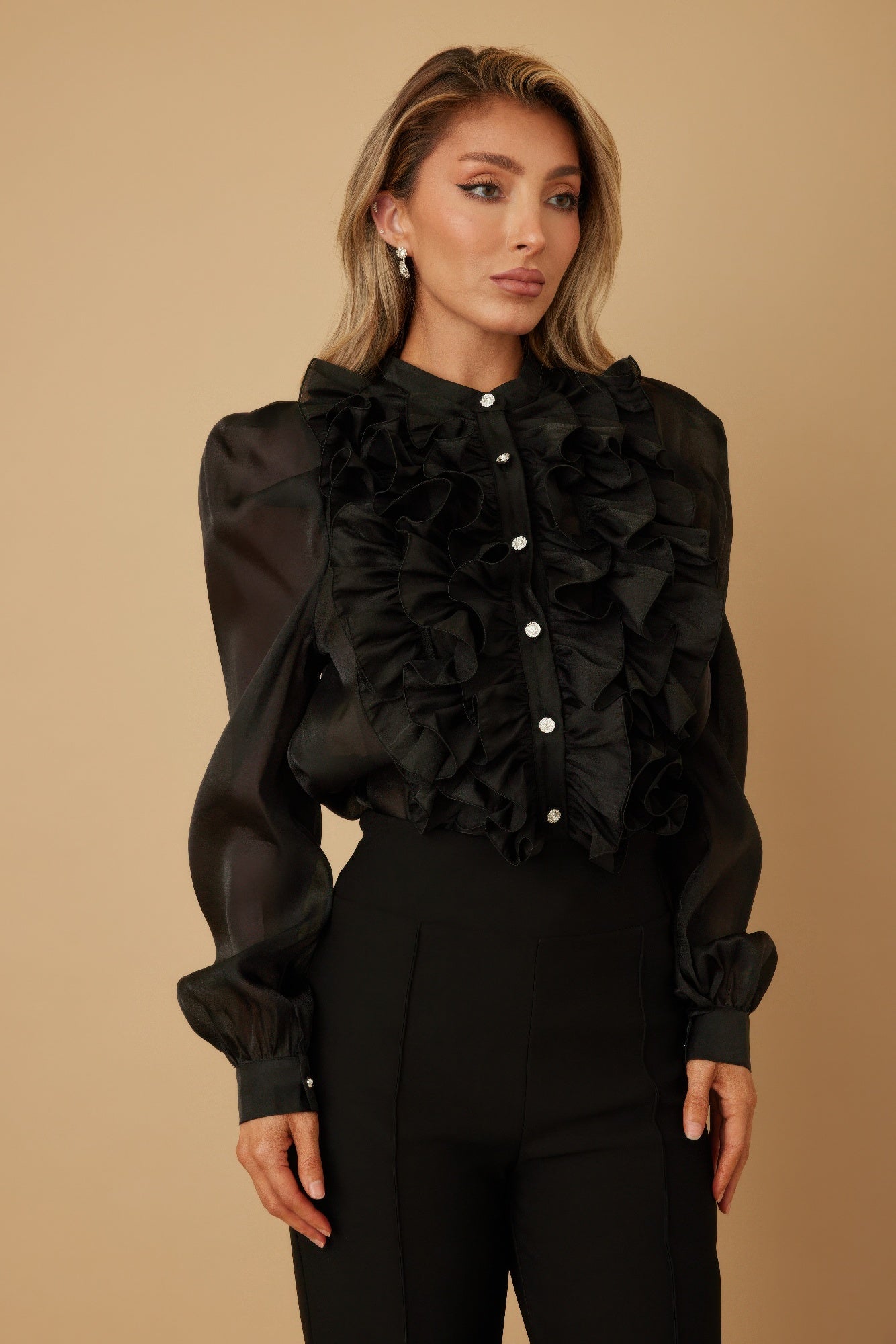 Black ruffle blouse with dramatic chest ruffles and long sleeves; button-up front detail.