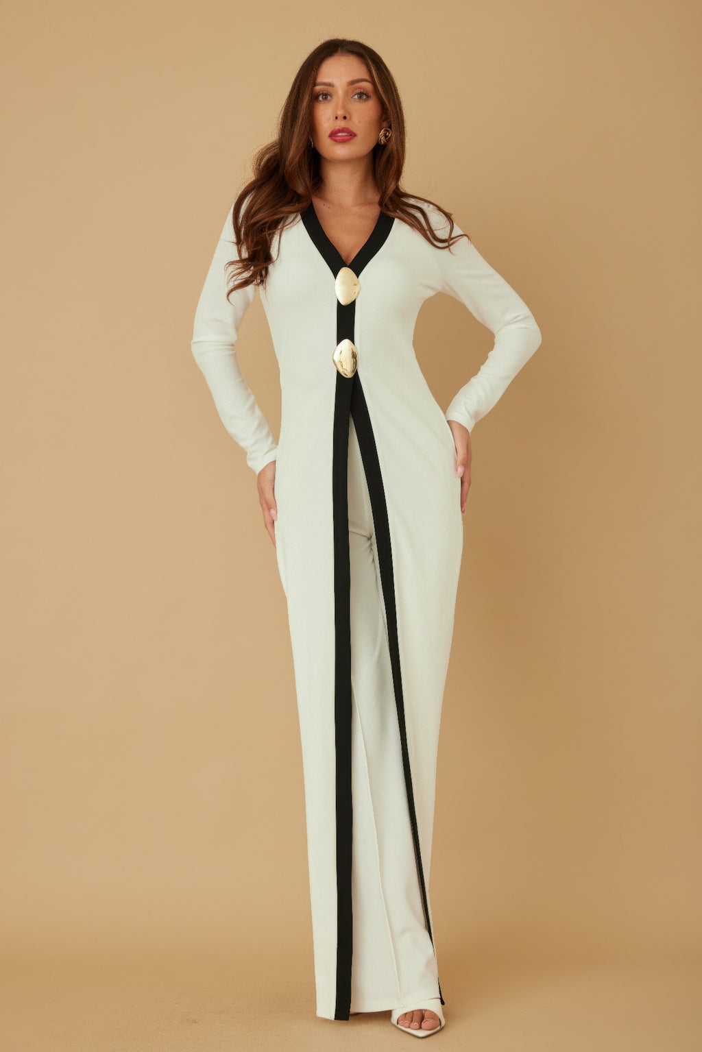 Cream long layer jumpsuit with black V-neck trim and oval gold mirror-stone buttons at center