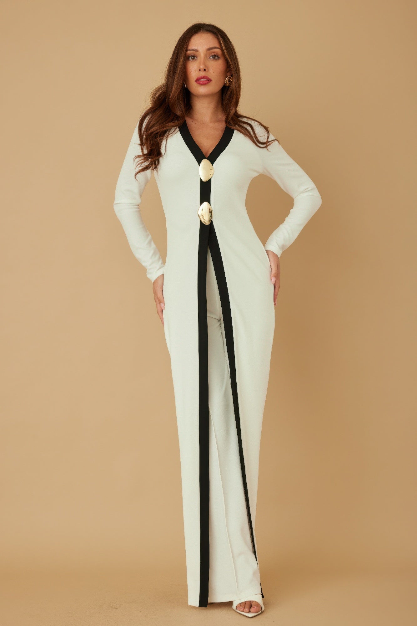 Cream long layer jumpsuit with black V-neck trim and oval gold mirror-stone buttons at center