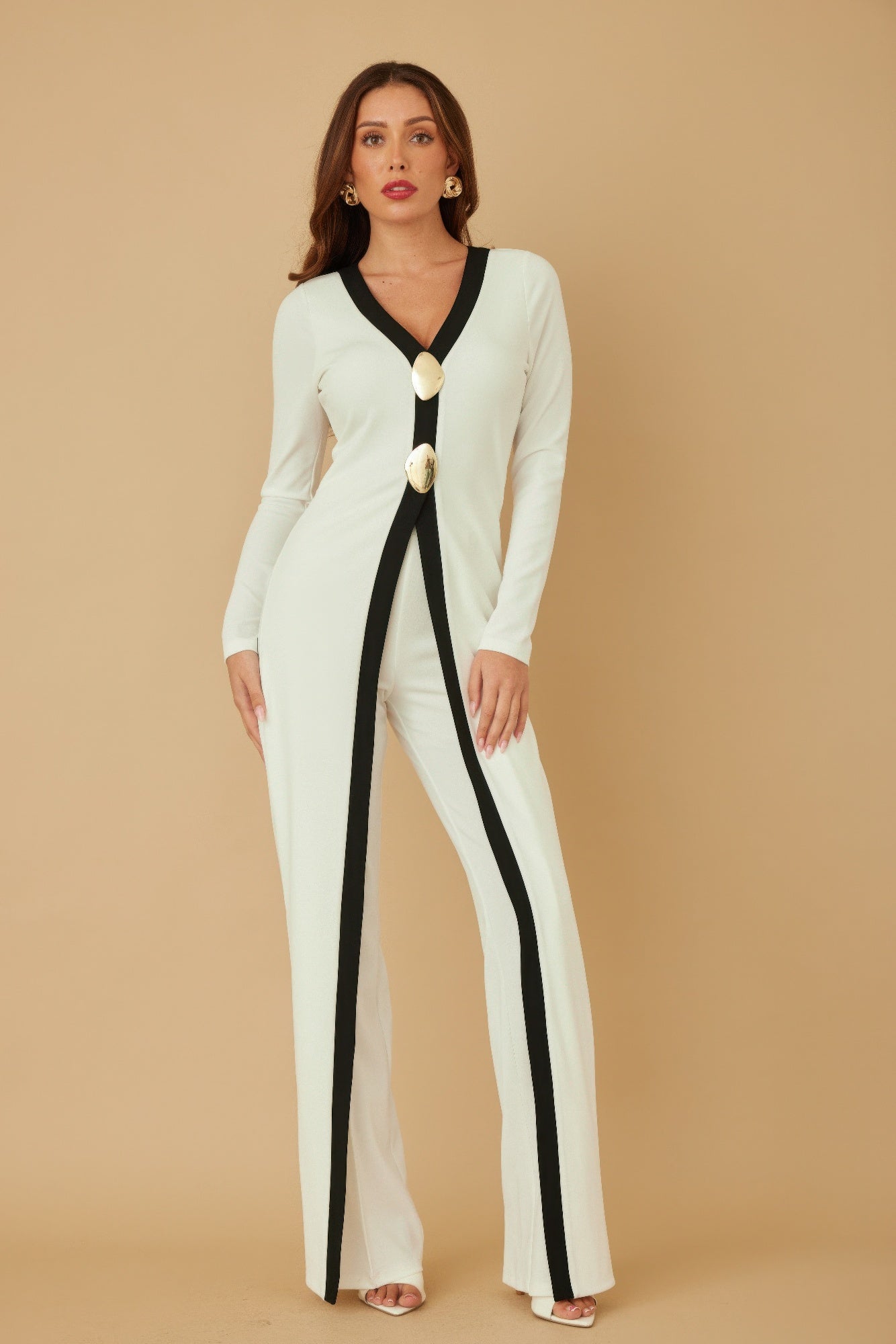 Tall profile cream jumpsuit with black trim stripe, V-neck, long sleeves, and mirror-stone buttons