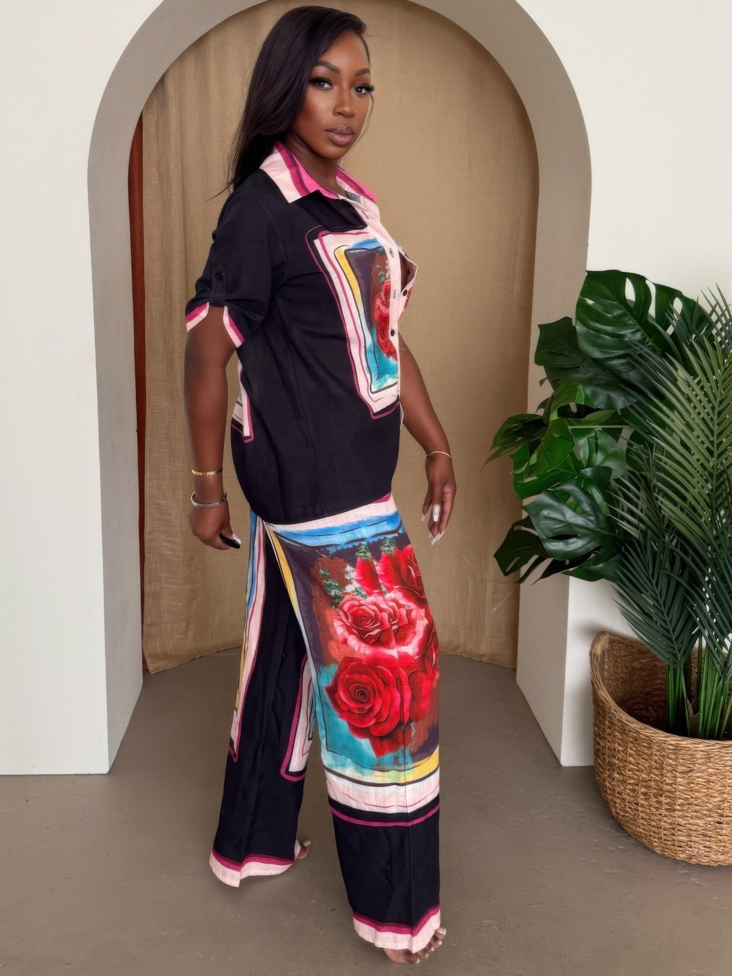 Framed resort set: black short-sleeve shirt with rose artwork pocket panels, matching pants