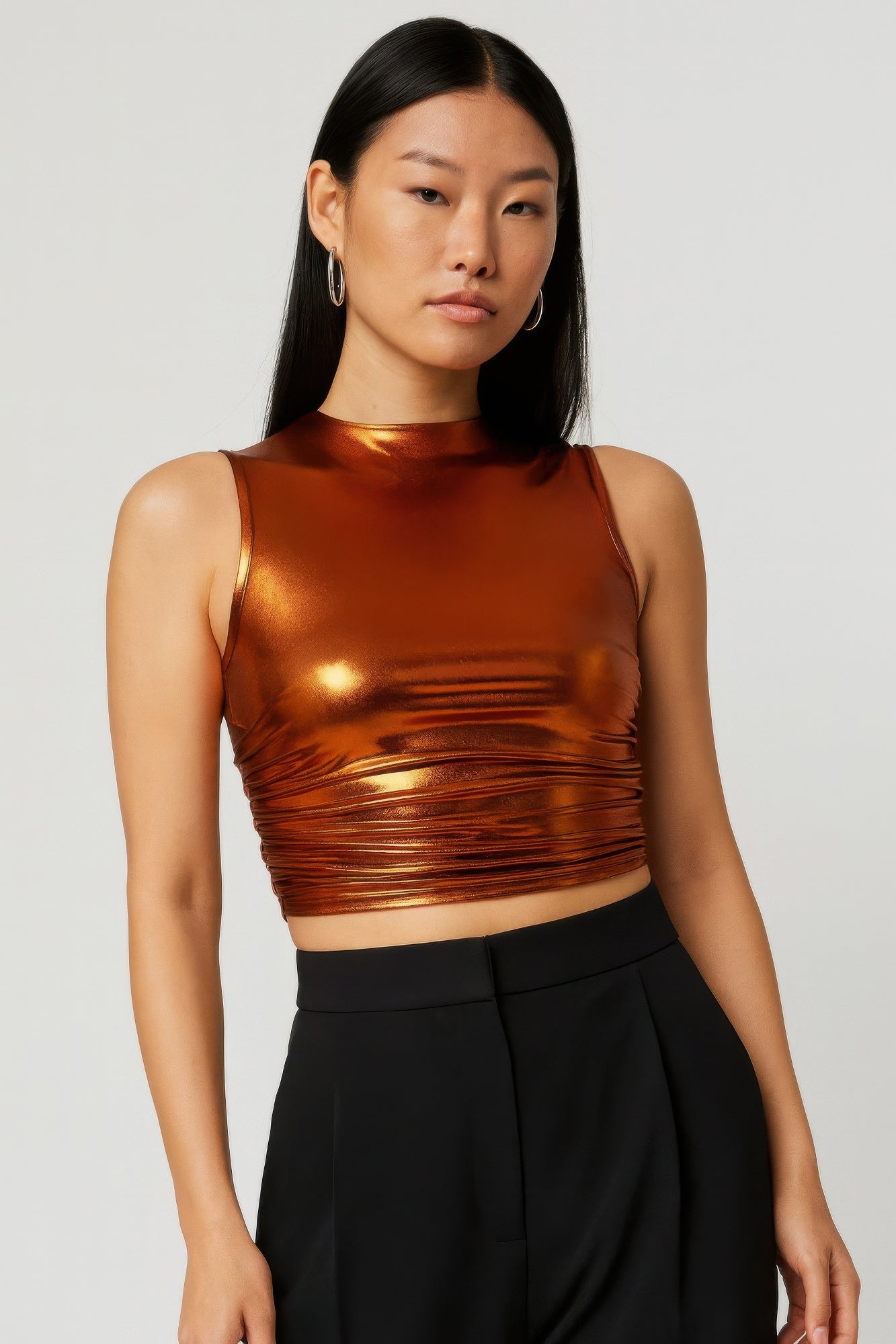 Metallic mock neck crop top with sleeveless design and bronze-gold shine