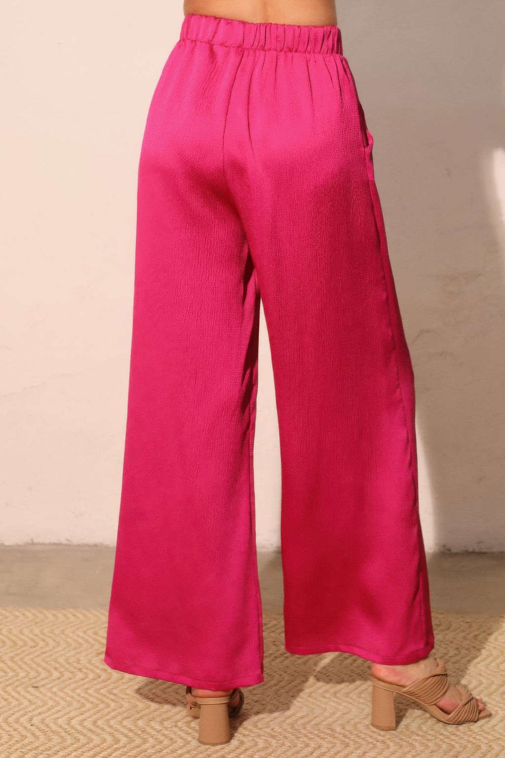 Fuchsia hammered satin pocket pants from side angle, elastic waist and wide silhouette