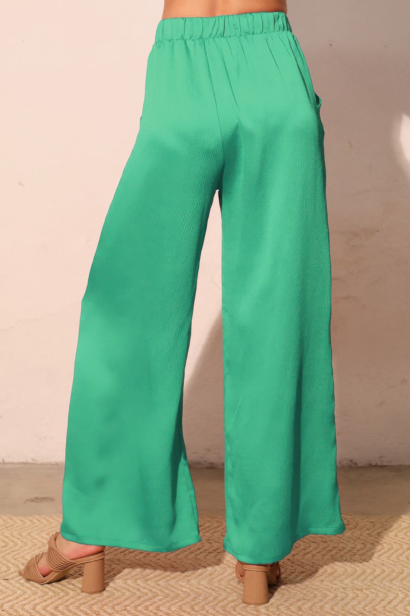 Green hammered satin pocket pants side view, elastic waist and wide flowing legs
