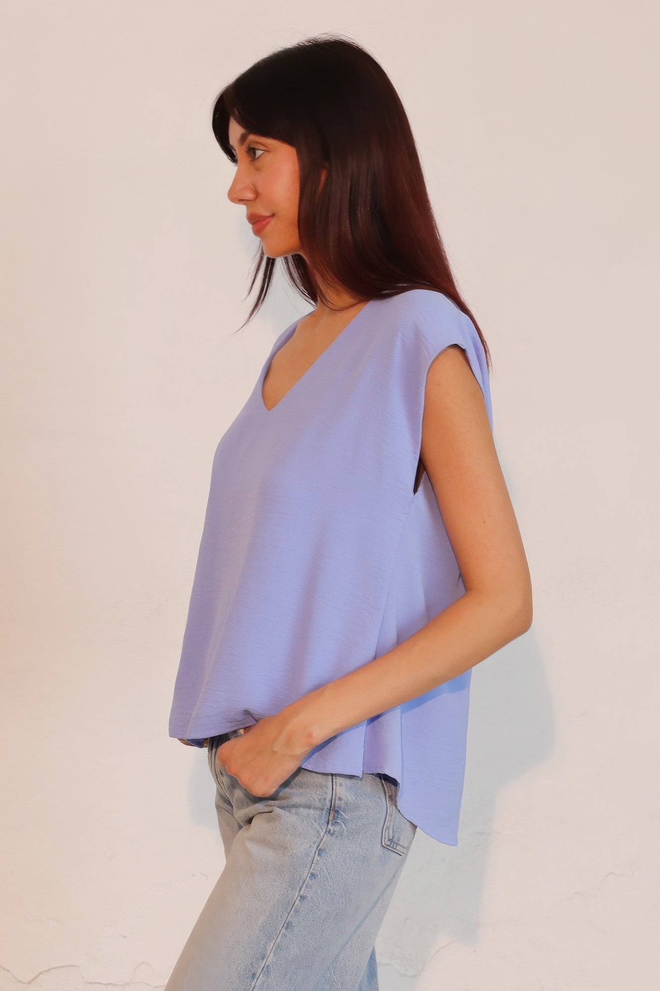 Denim blue loose V-neck crepe top, short sleeves and draped sides.