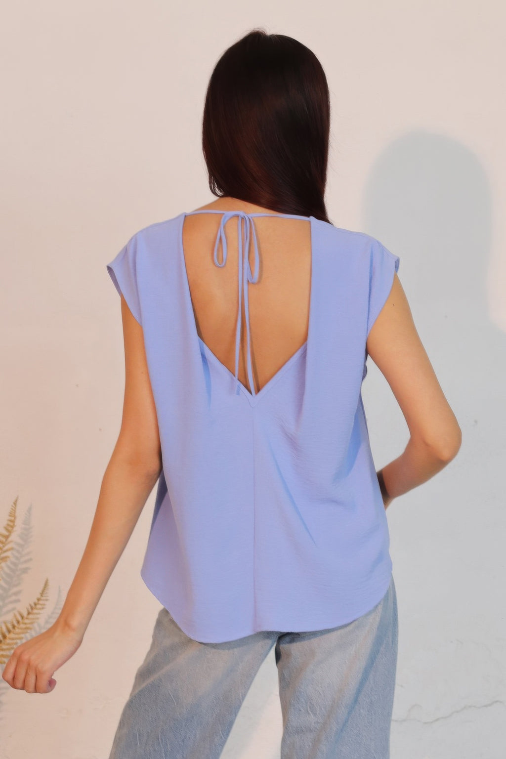 Denim blue low-back crepe top with open back and tie drawstrings.