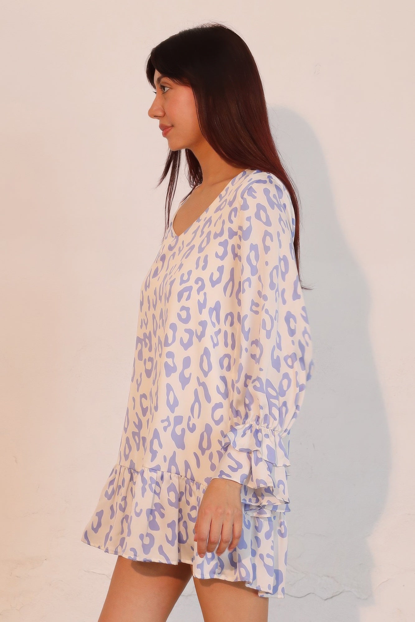 Side view: blue leopard print V-neck mini dress with ruffle cuffs and layered tiers