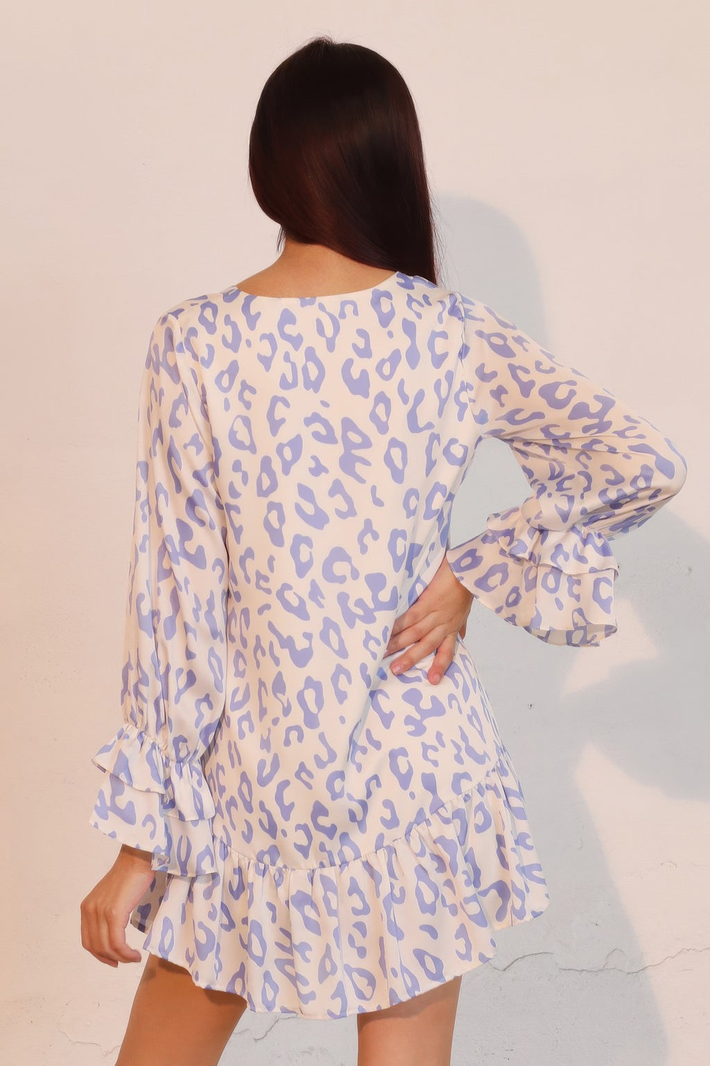 Back view: blue leopard print mini dress with long sleeves, ruffle cuffs, tiered skirt