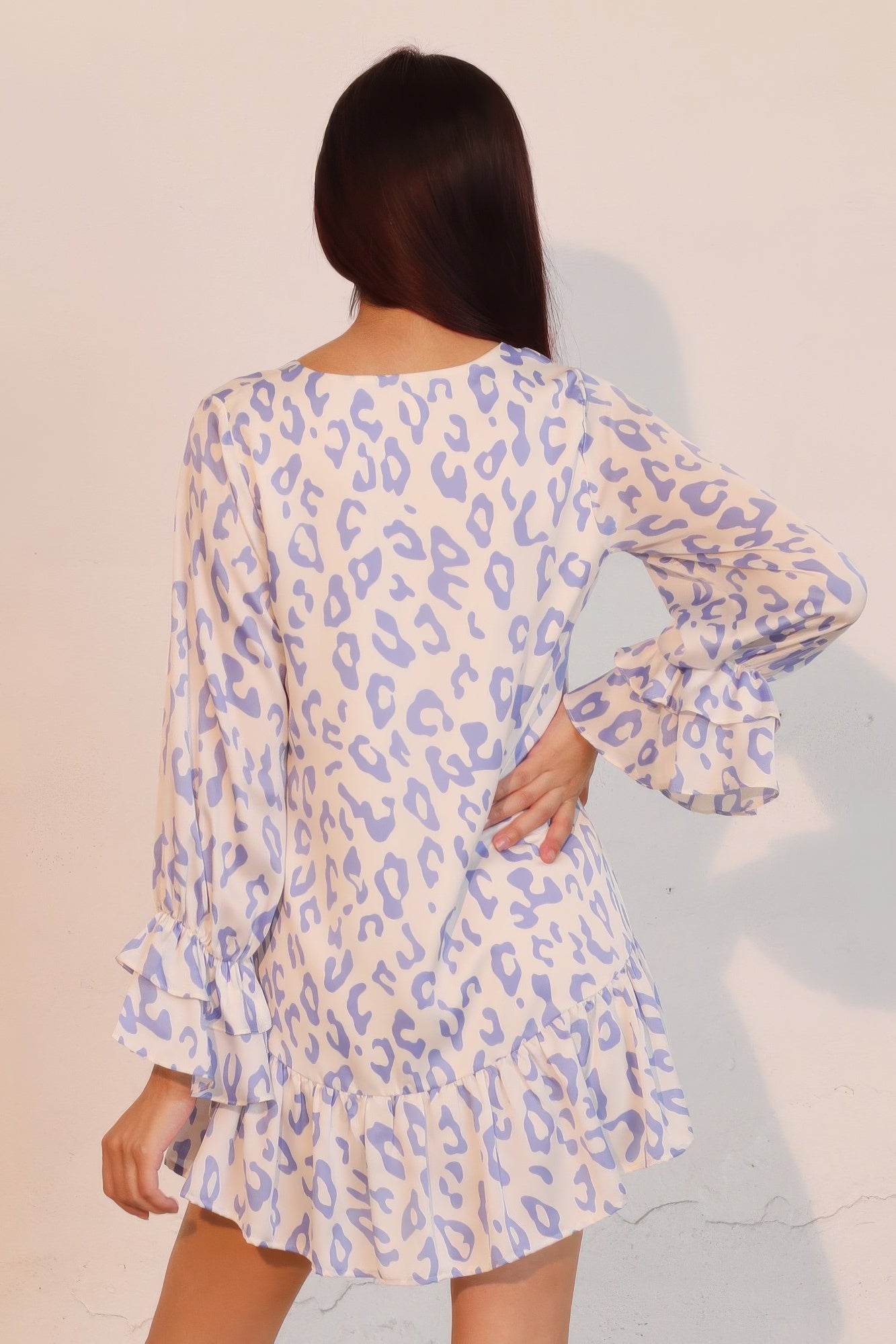 Back view: blue leopard print mini dress with long sleeves, ruffle cuffs, tiered skirt