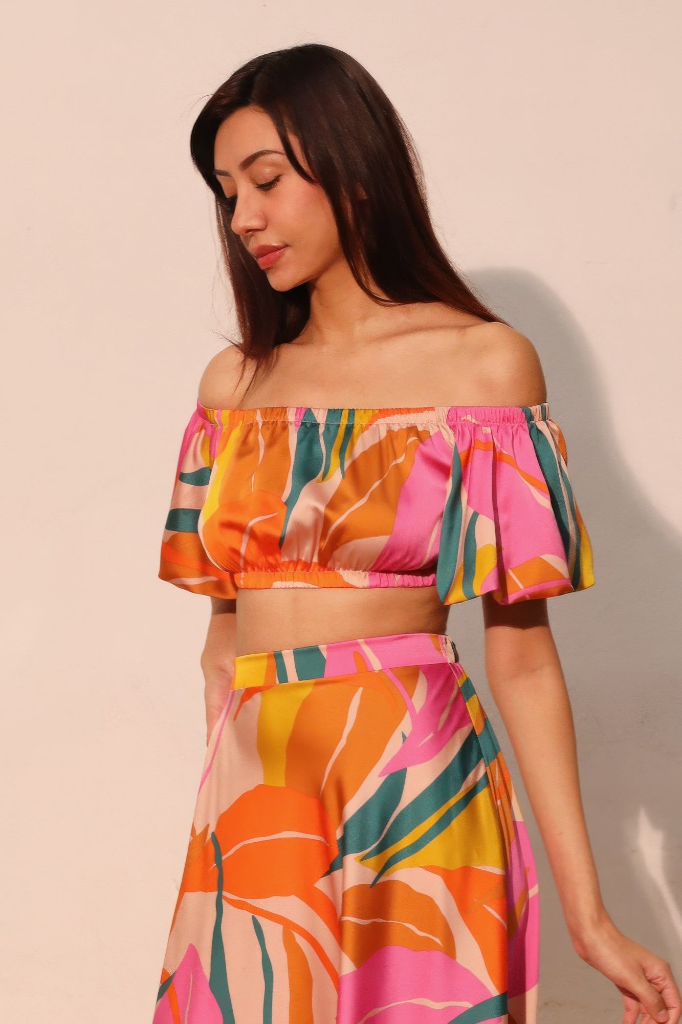 Isla Tropical crop top satinado con escote elástico bardot y mangas globo, estampado colorido