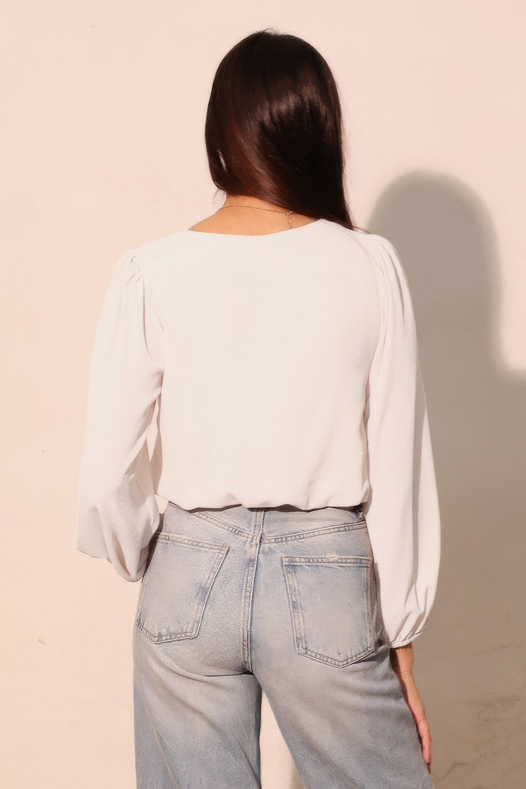 Back view white long-sleeve crop top with voluminous sleeves and elastic cuffs