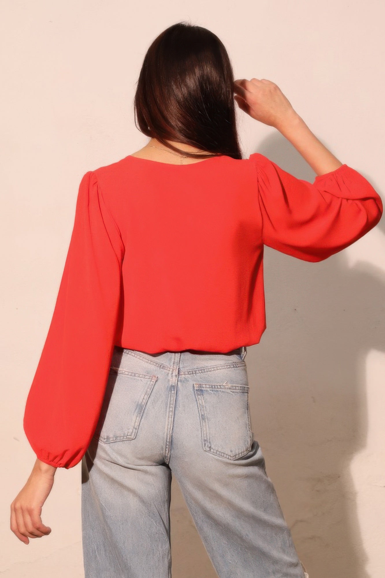 Back view: tomato red long-sleeve crop top with voluminous sleeves and gathered cuffs