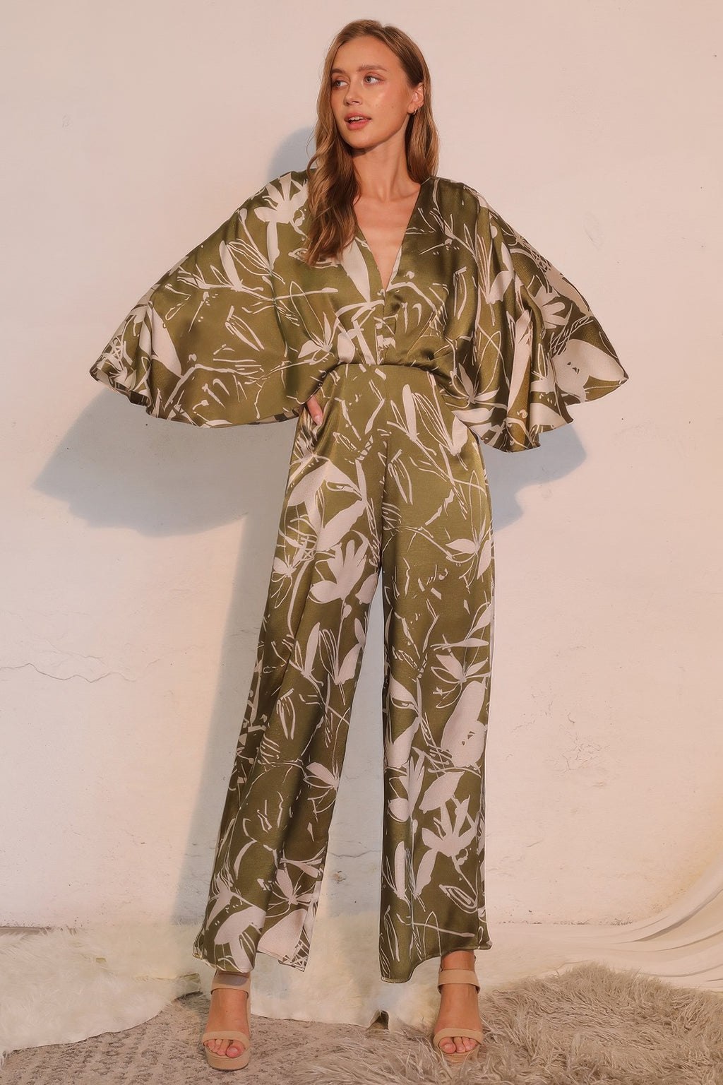 Olive satin cape jumpsuit with V-neck and flowing wide-leg pants