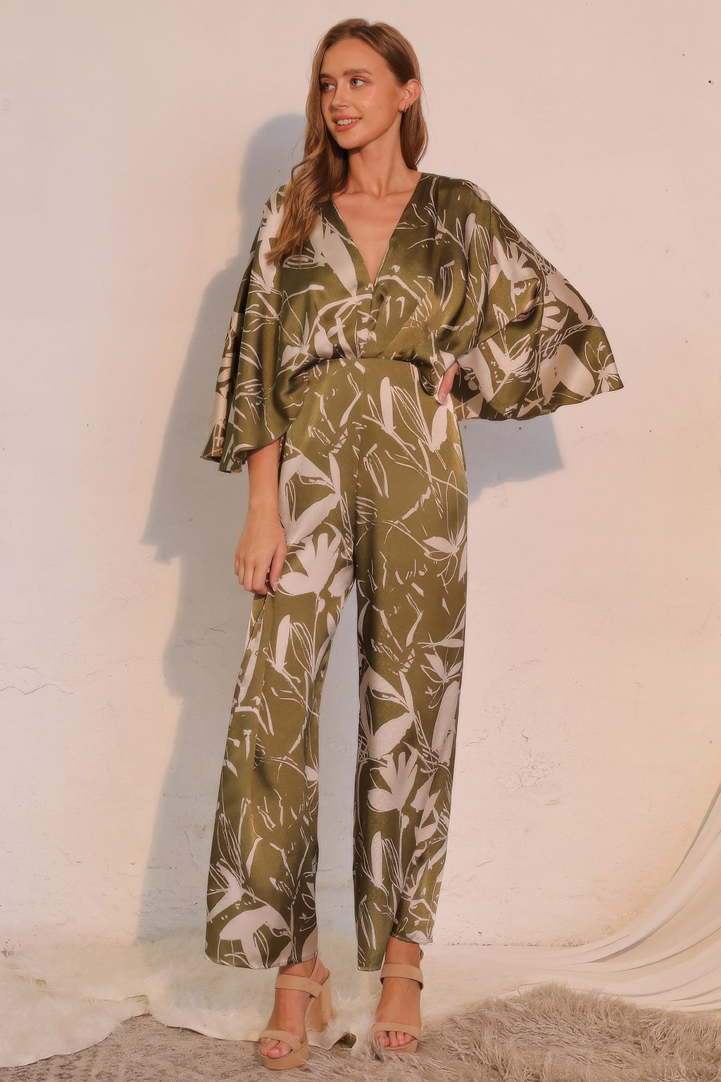 Olive satin cape jumpsuit with belted waist, V-neck, and wide legs