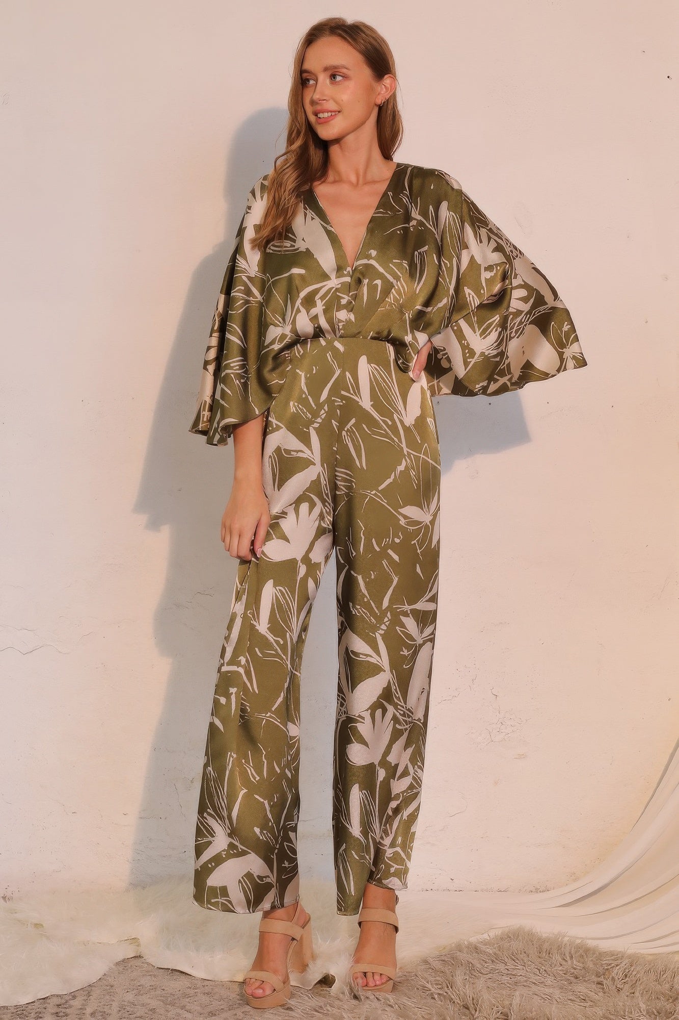 Olive satin cape jumpsuit with belted waist, V-neck, and wide legs