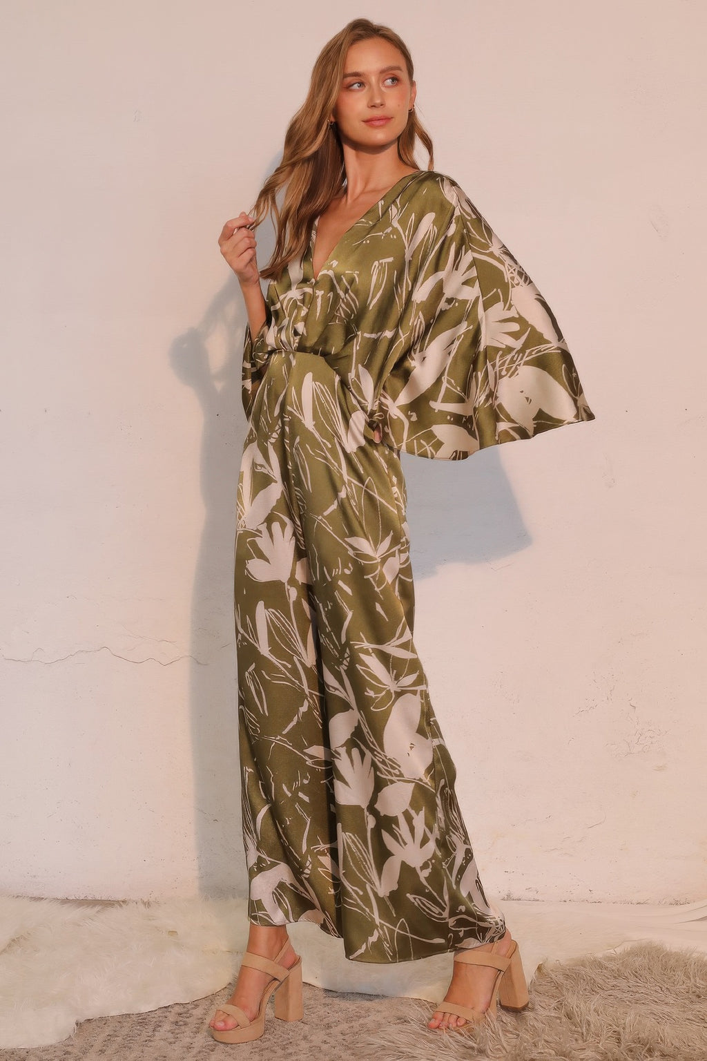 Olive satin jumpsuit with flutter cape sleeves and botanical print wide pants