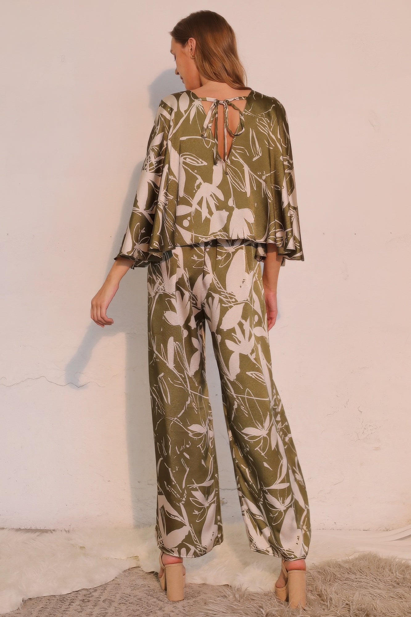 Back view of olive satin cape jumpsuit with tie-up detail and wide legs