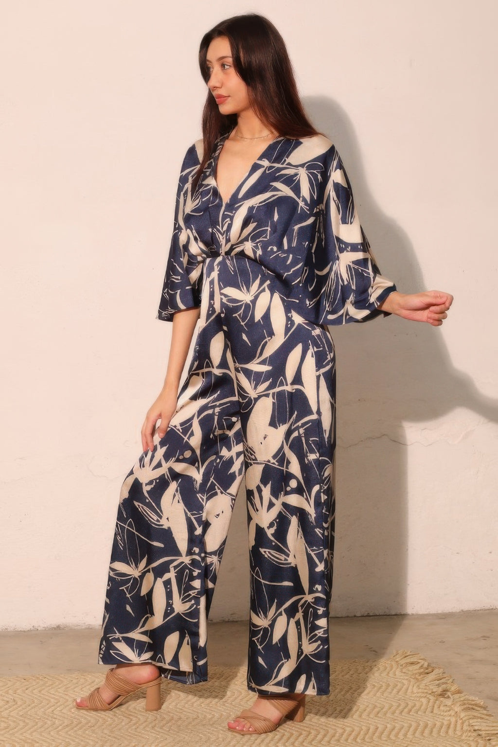 Navy satin cape jumpsuit with V-neck and flowing wide-leg silhouette