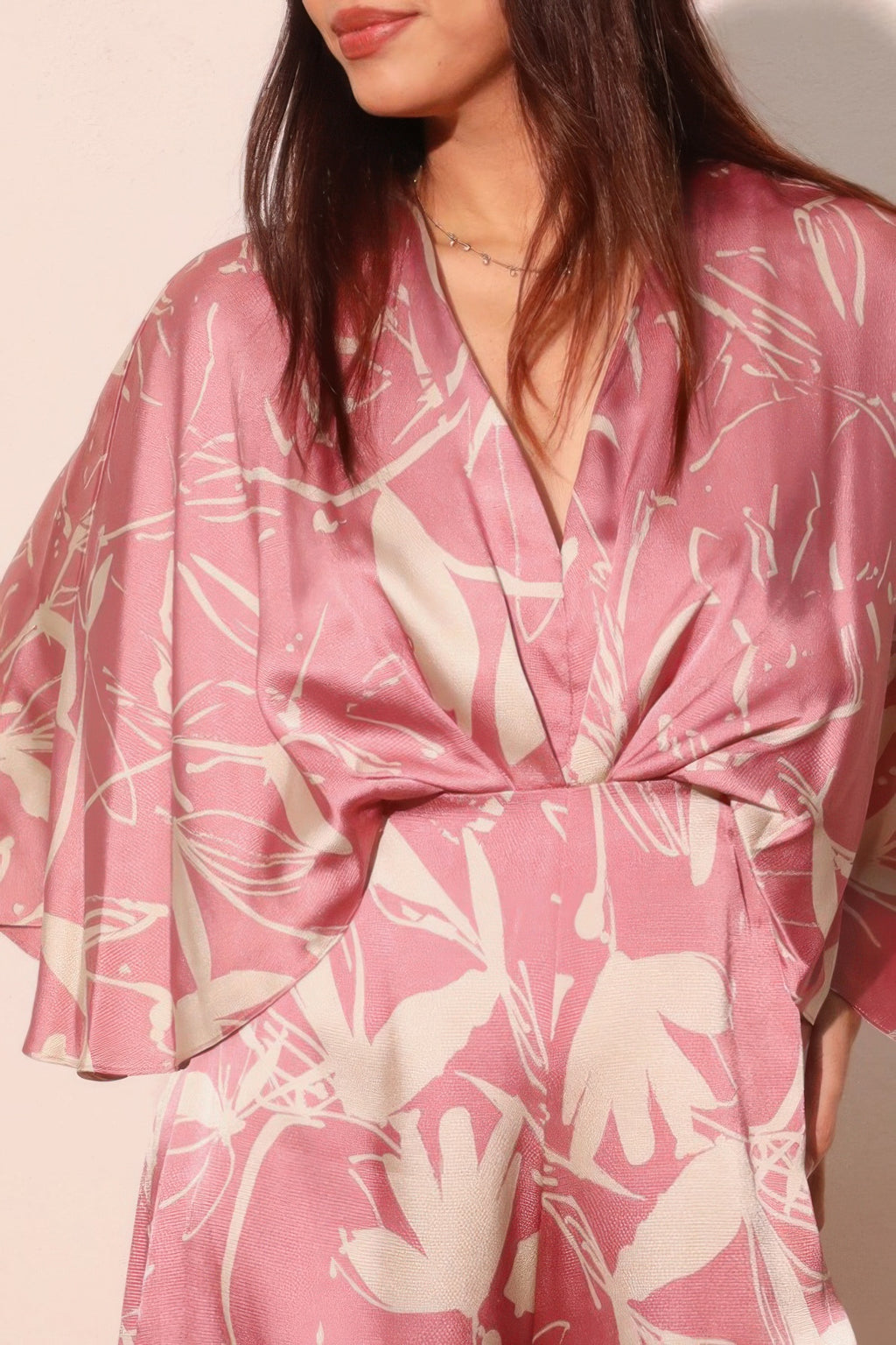 Pink satin cape jumpsuit detail: V-neck wrap front and floral print