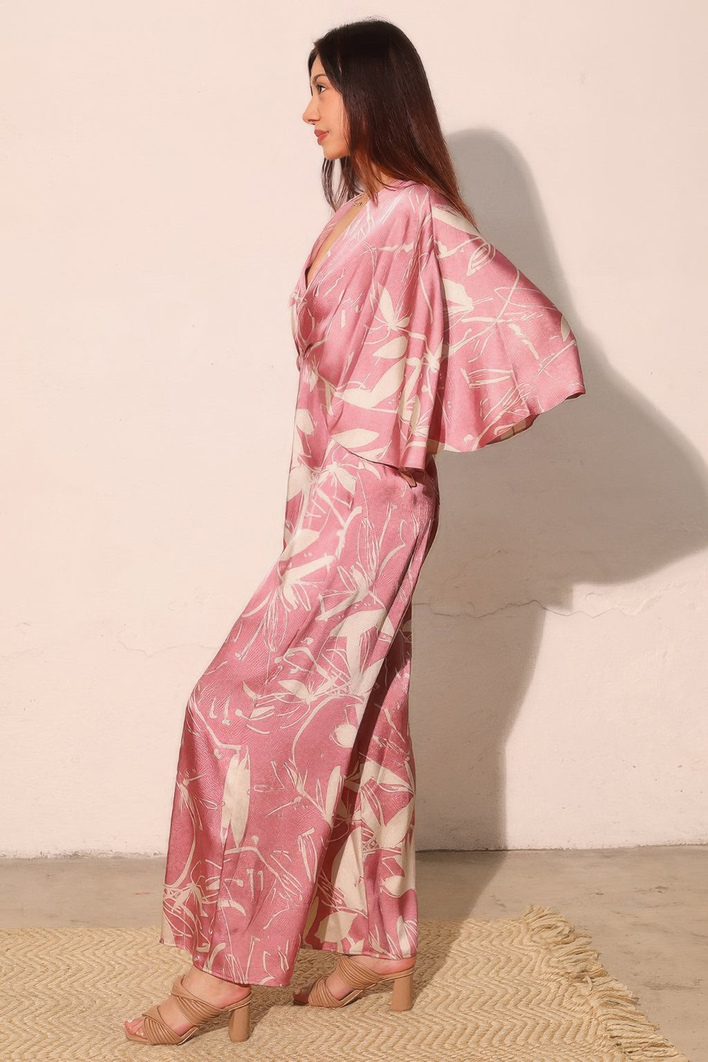 Pink satin wide-leg jumpsuit with flowing cape sleeve drape and floral print