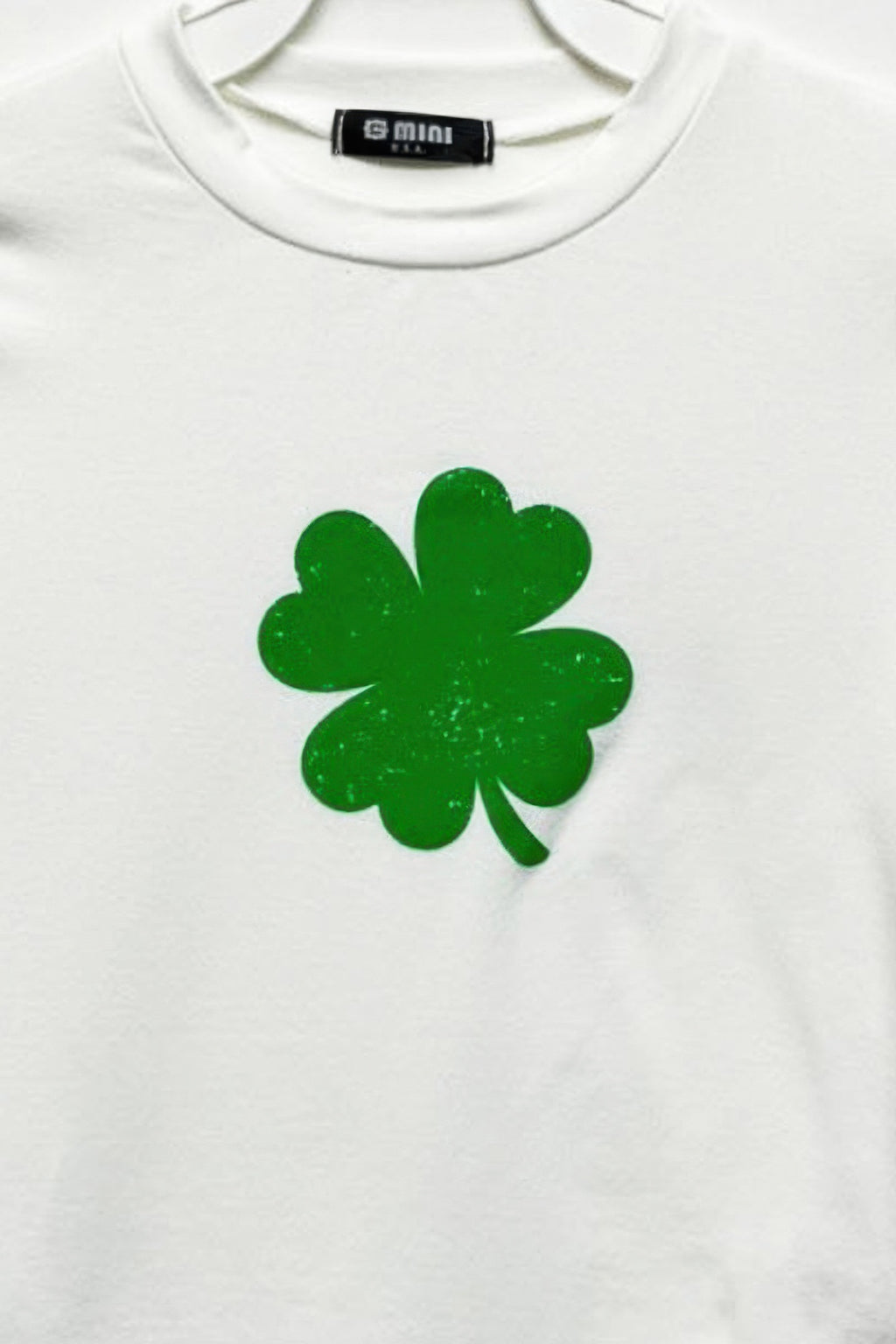 Ivory cotton top with green four-leaf clover graphic on front