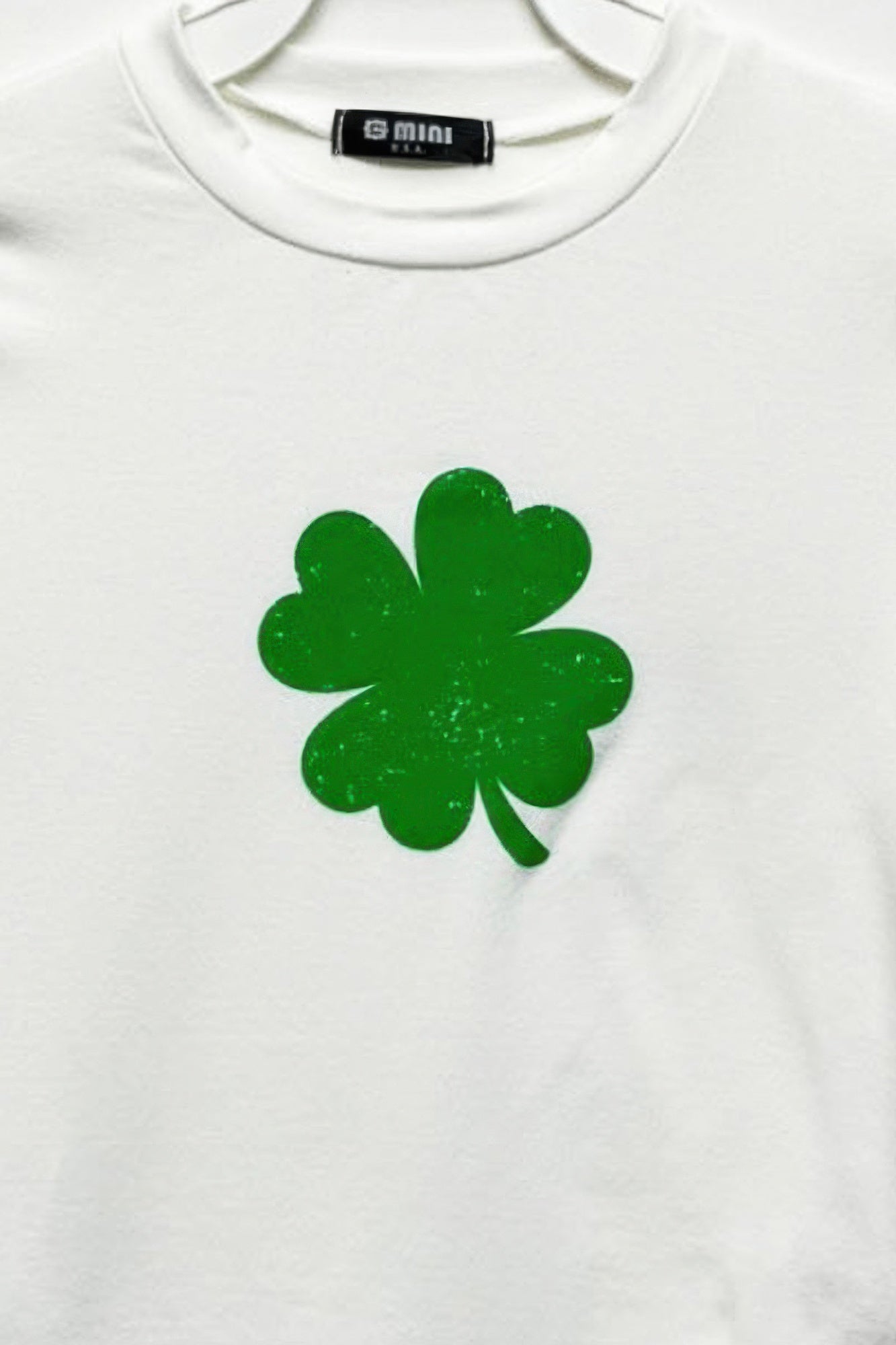 Ivory cotton top with green four-leaf clover graphic on front