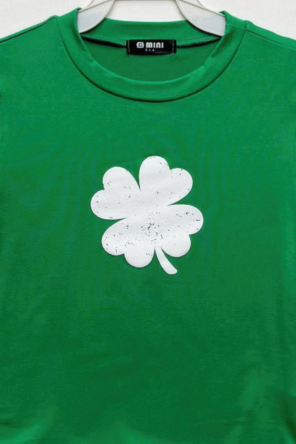 Kelly green cotton top, white four-leaf clover graphic at chest