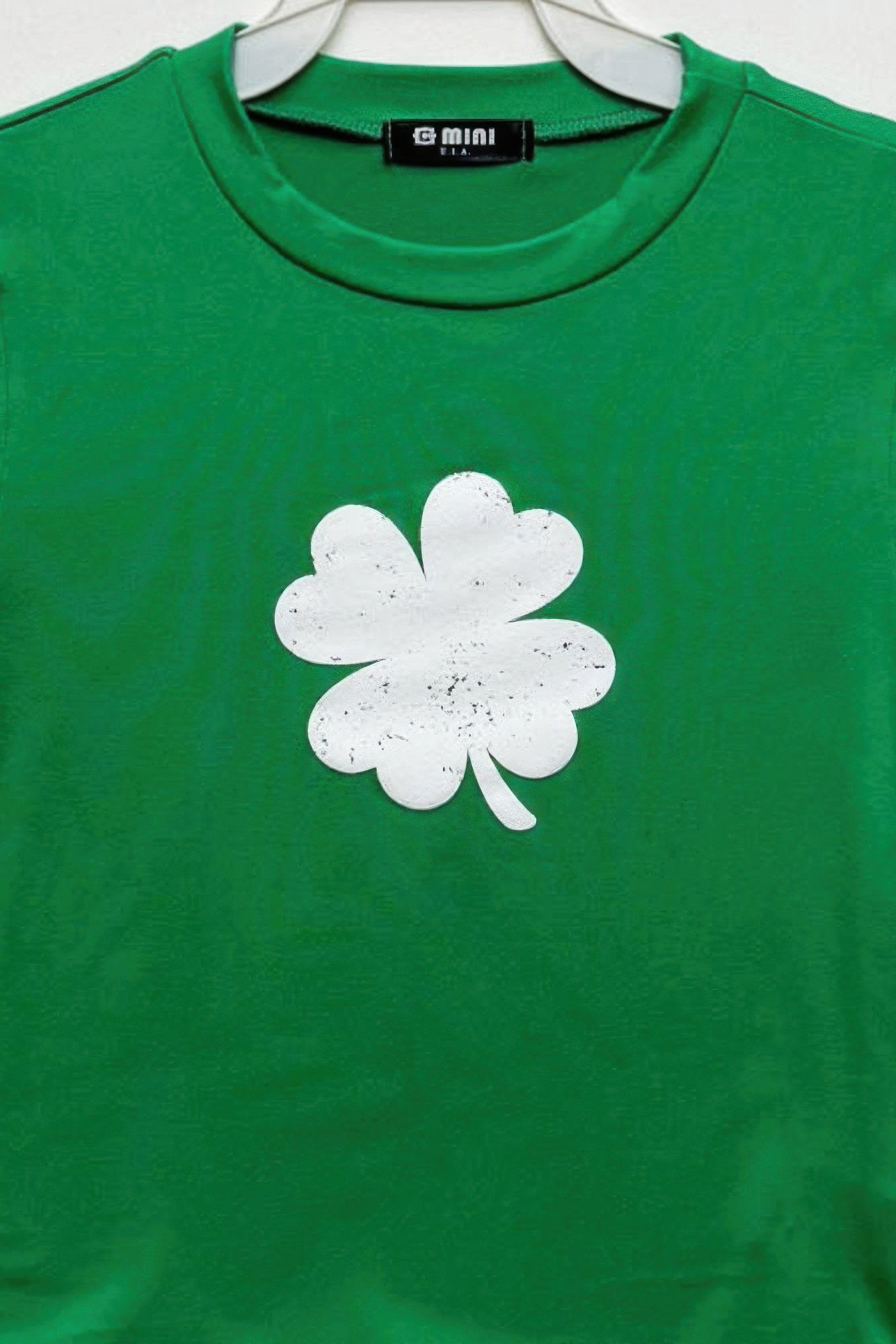 Kelly green cotton top, white four-leaf clover graphic at chest