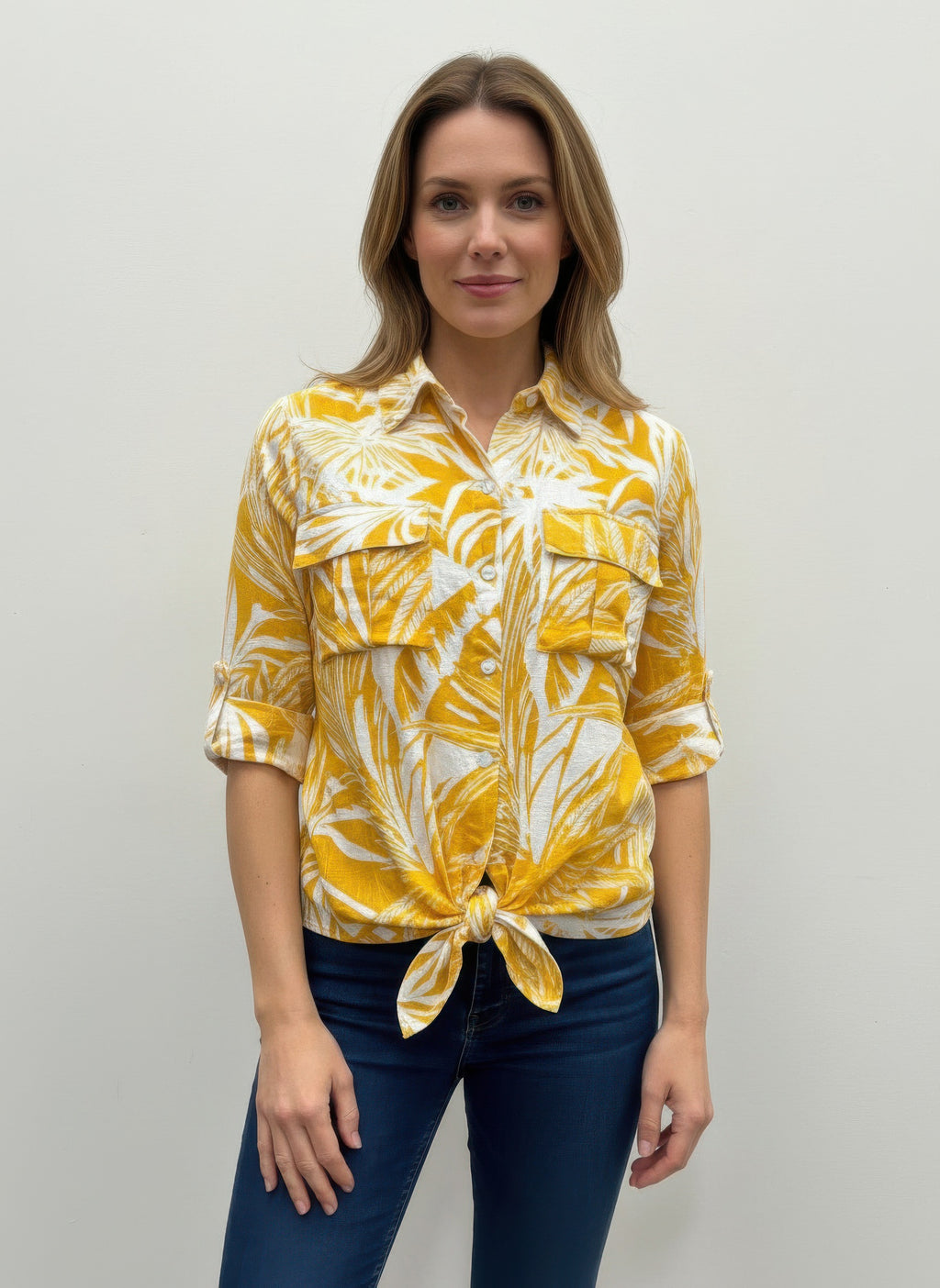 Women’s blouse in yellow with white leaf print, button front, tied hem