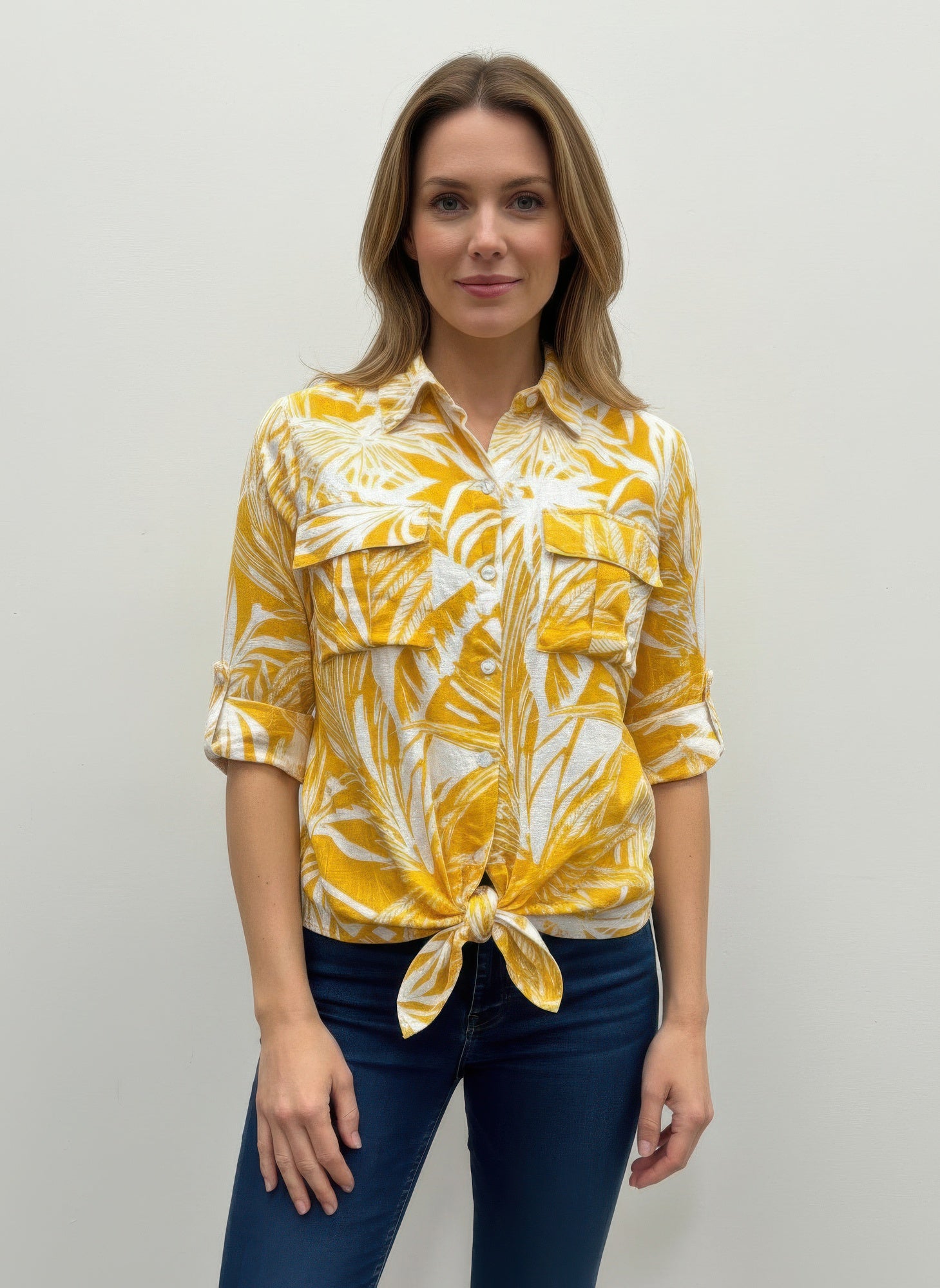 Women’s blouse in yellow with white leaf print, button front, tied hem