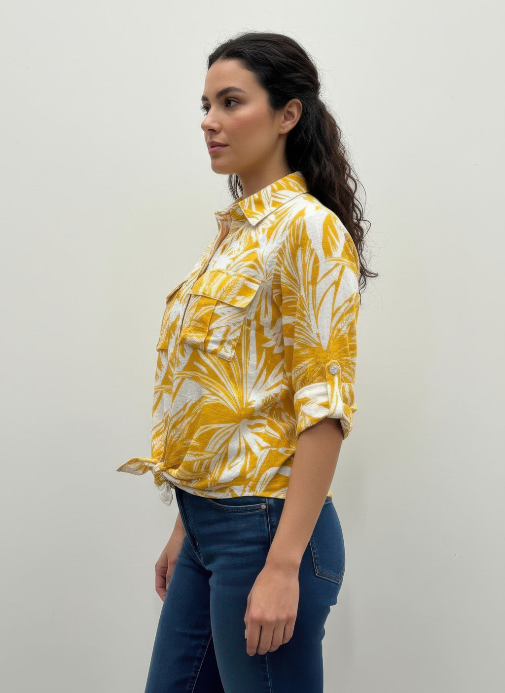 Yellow leaf-print blouse with ruffled shoulder details and button-up front