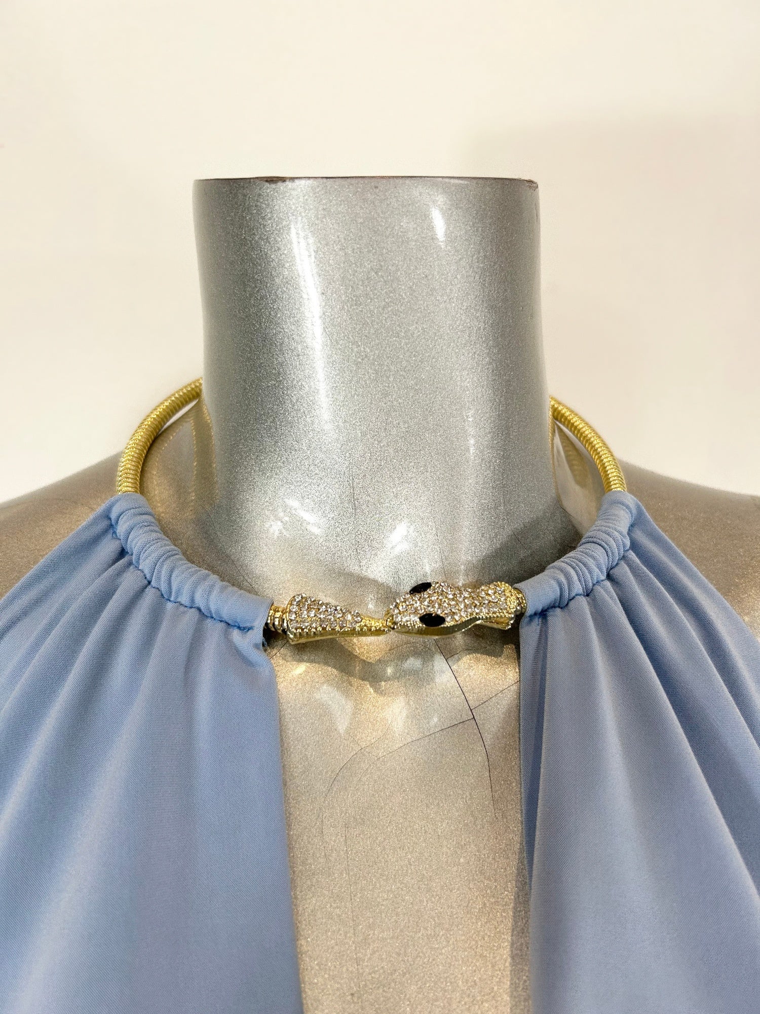 Light blue draped cowl mini dress neckline with gold beaded necklace detail
