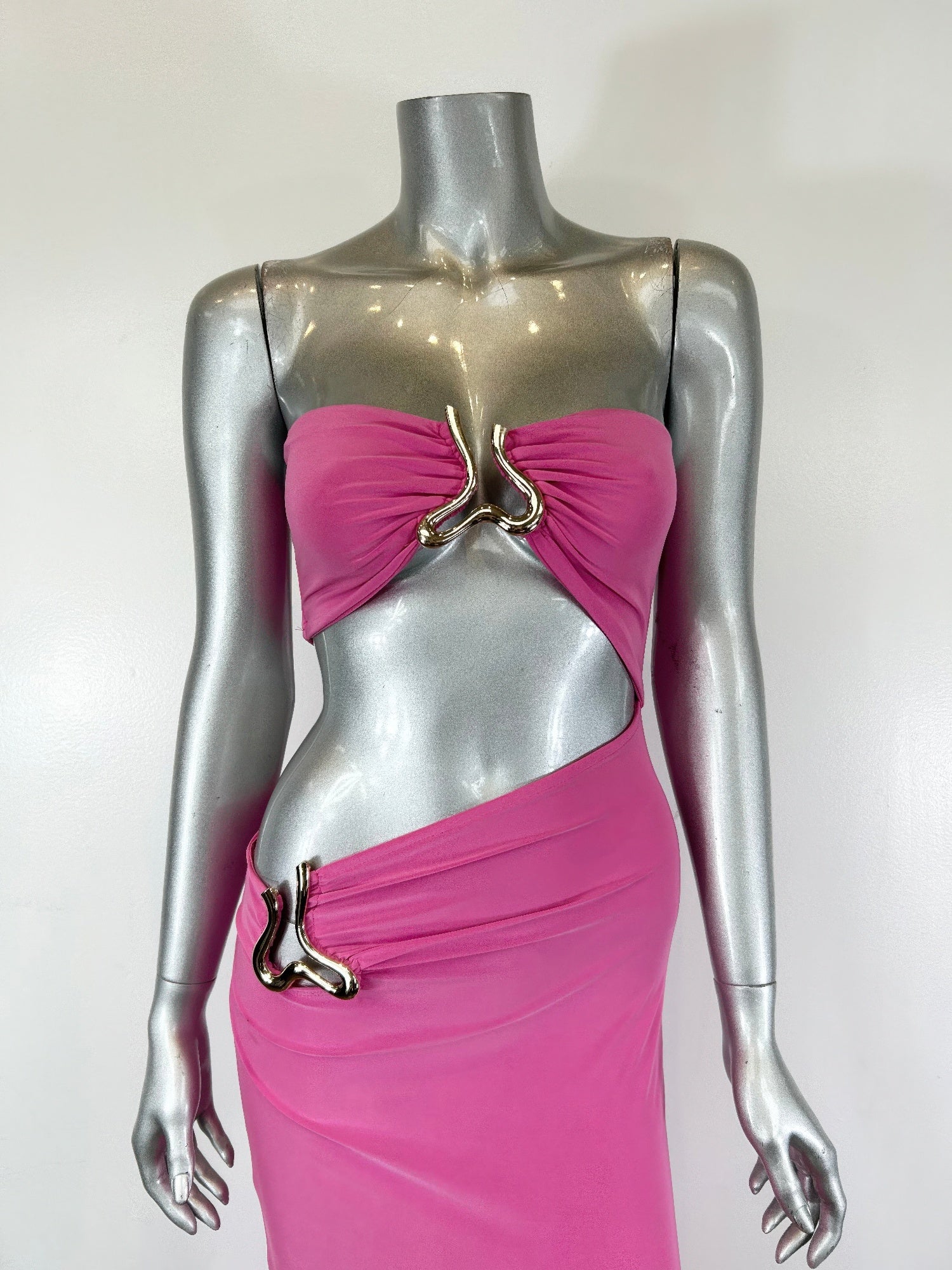 Fuchsia midi dress on mannequin: triangular cutout bust with metal ring trim and side drape