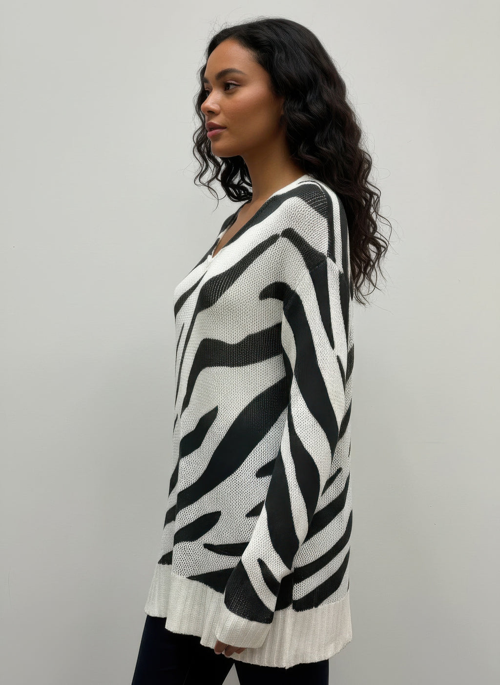 Pull-over sweater with zebra stripes, long sleeves and ribbed cuffs, side view