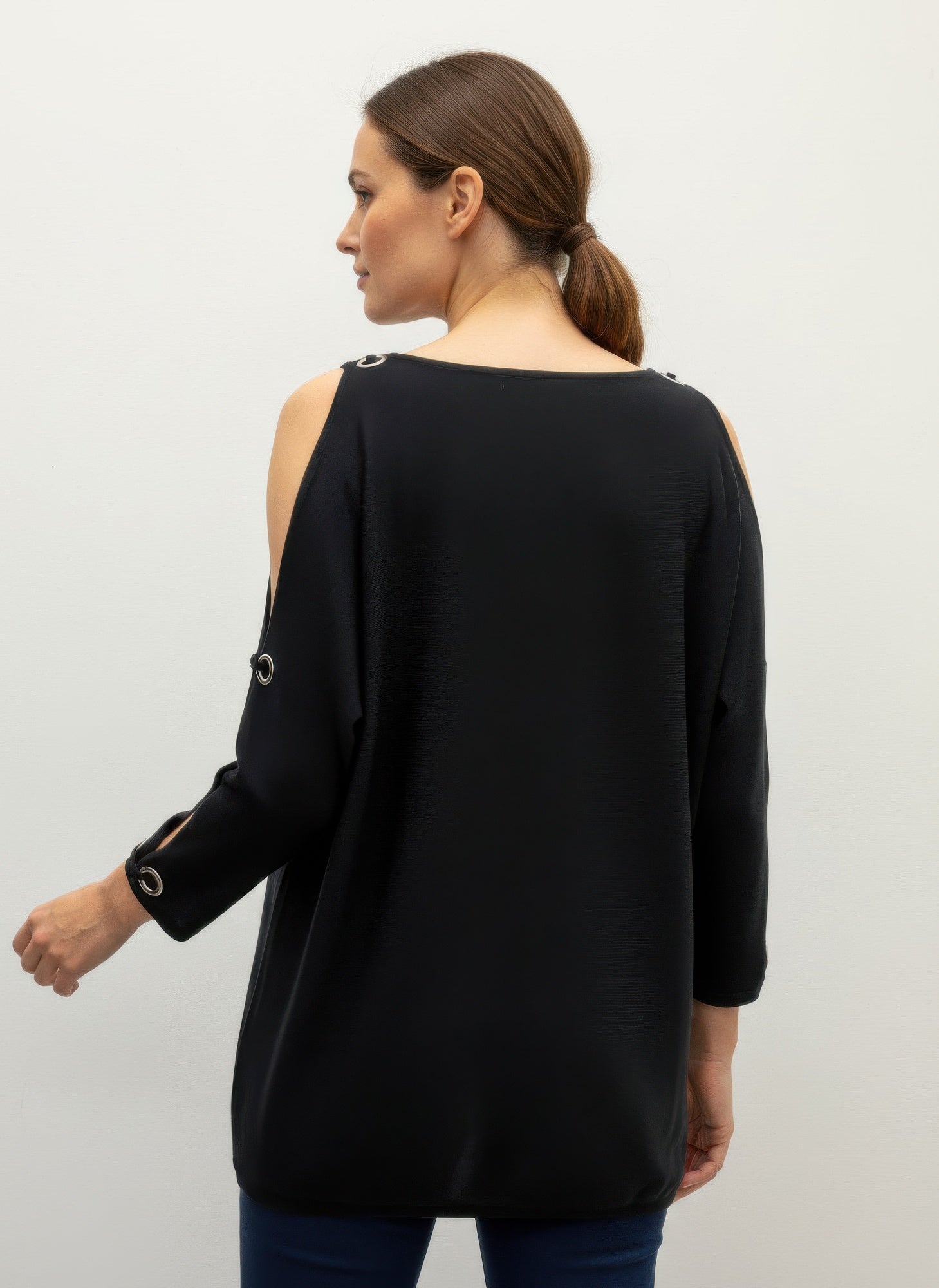Black cable knit pullover sweater, back view with open shoulder and eyelet cuff accents