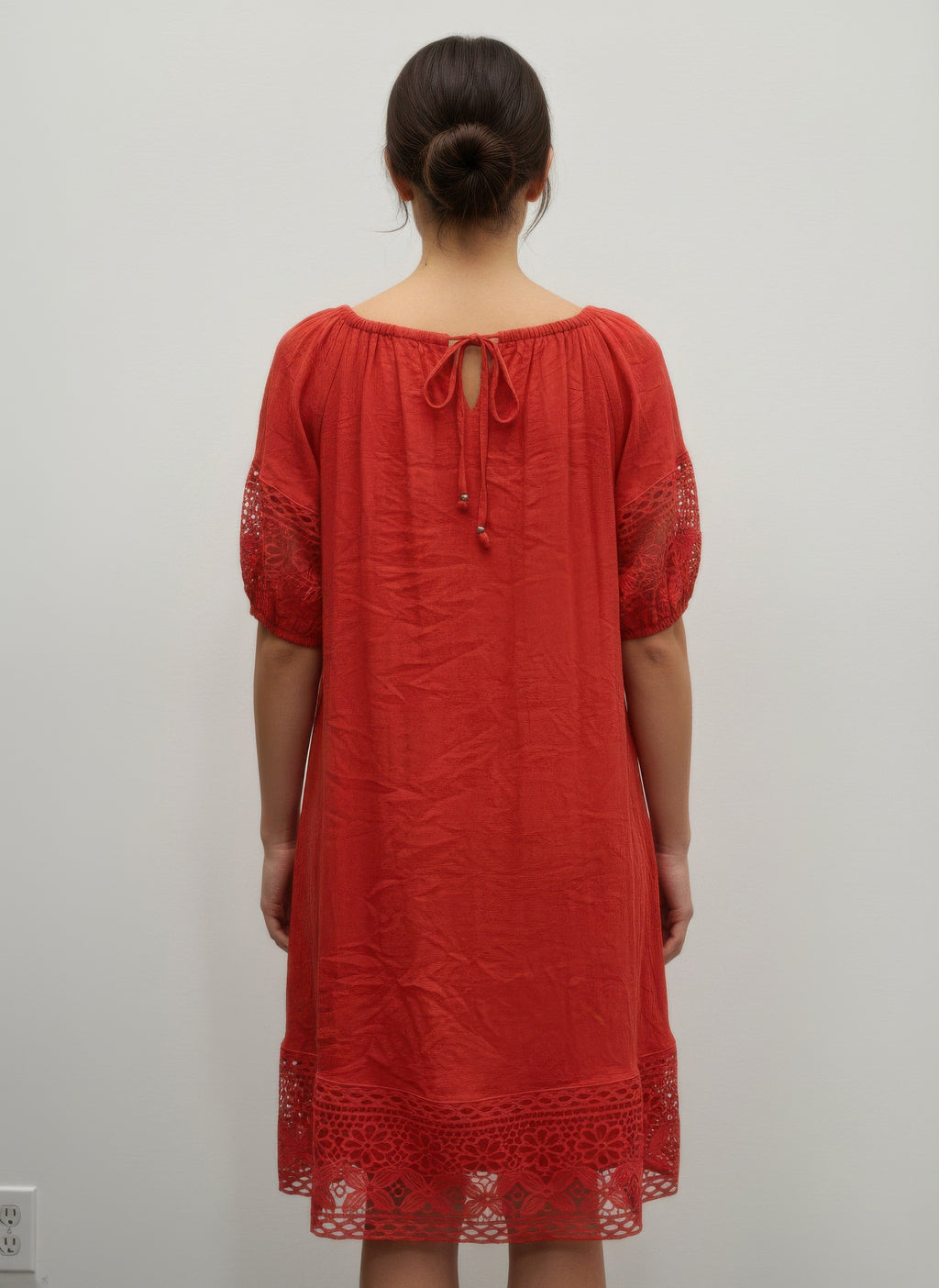 Back view: coral-red solid short-sleeve dress with lace sleeves and tie neckline
