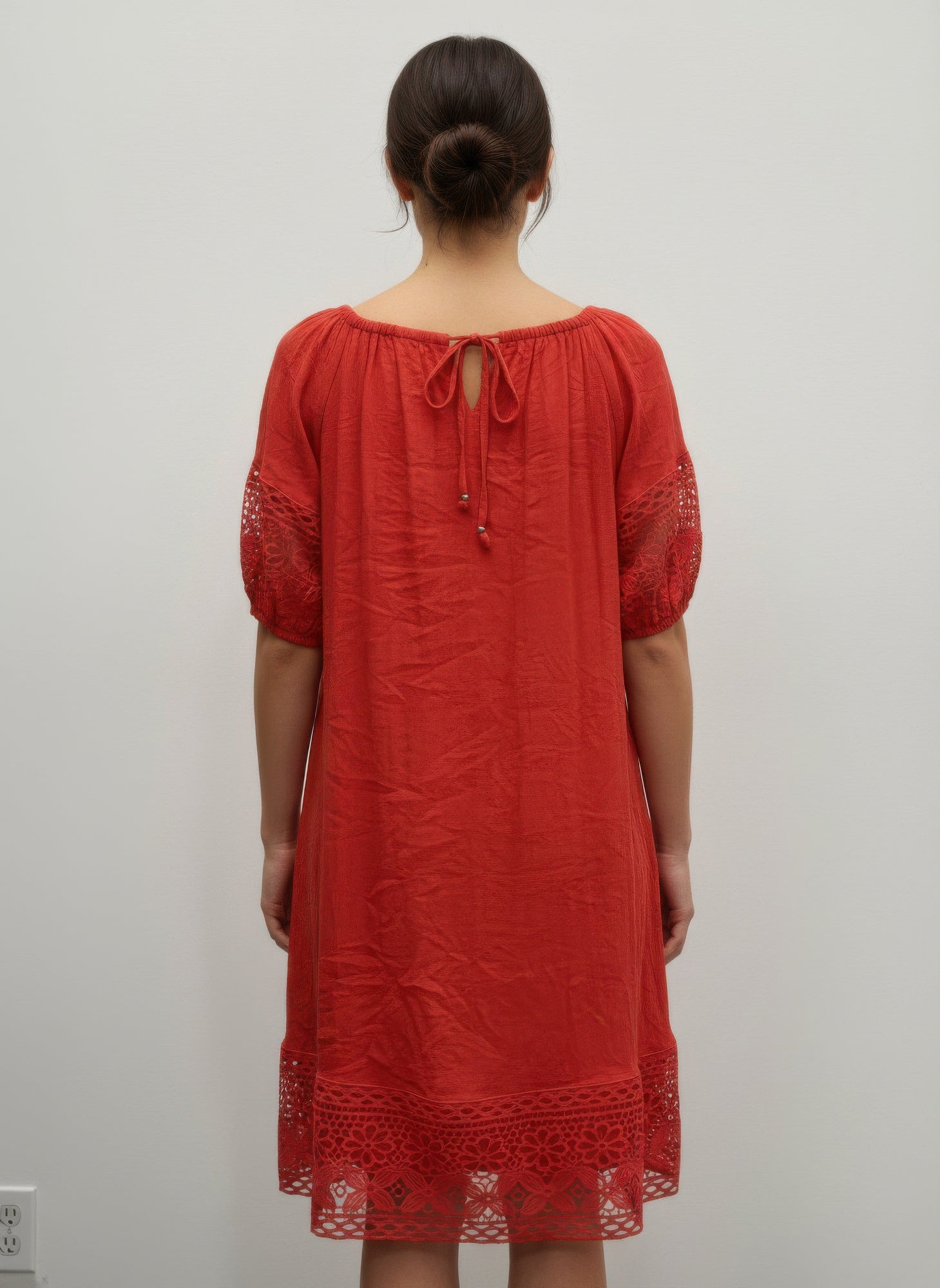 Back view: coral-red solid short-sleeve dress with lace sleeves and tie neckline