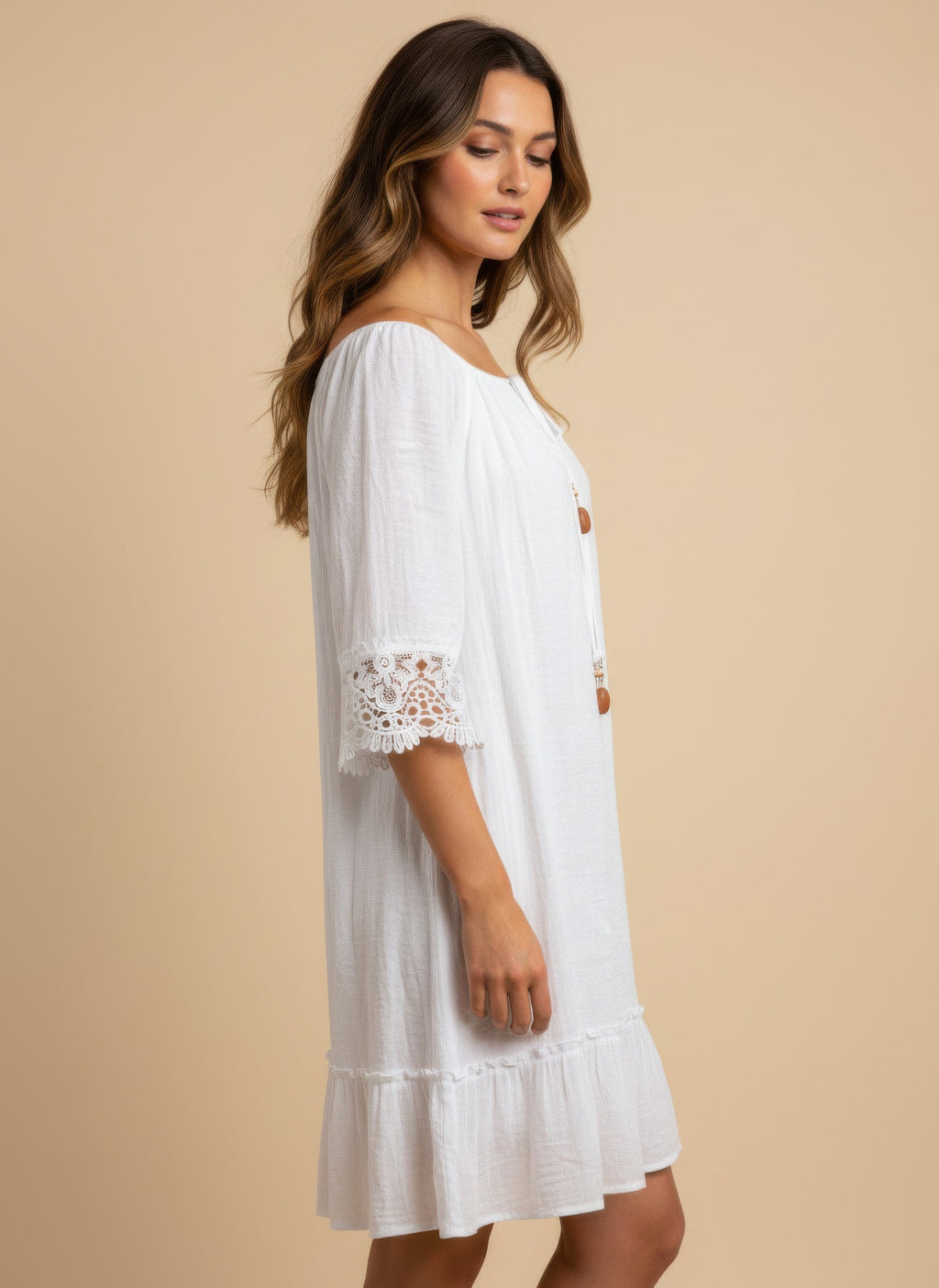 White dress side view, lace-trim elbow sleeves and gathered tiered skirt