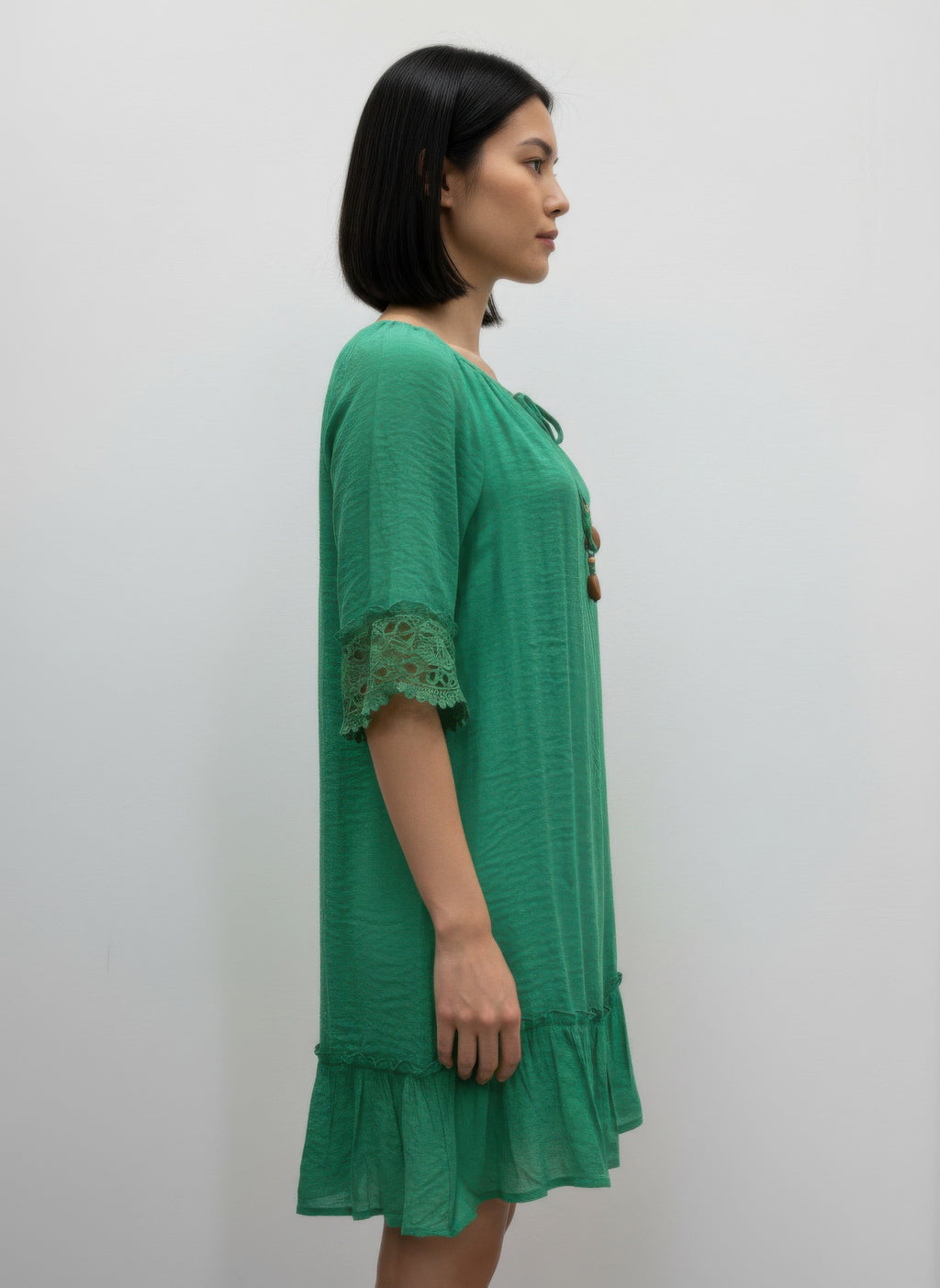 Solid color green elbow-sleeve dress with lace-trimmed sleeves and tiered skirt