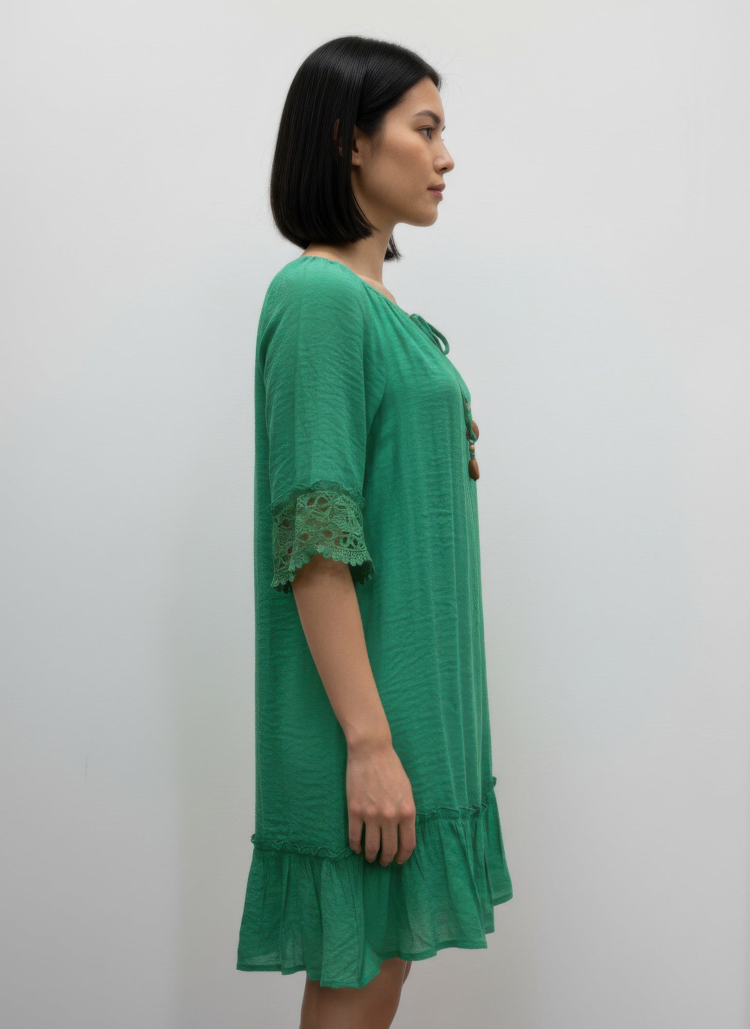 Solid color green elbow-sleeve dress with lace-trimmed sleeves and tiered skirt