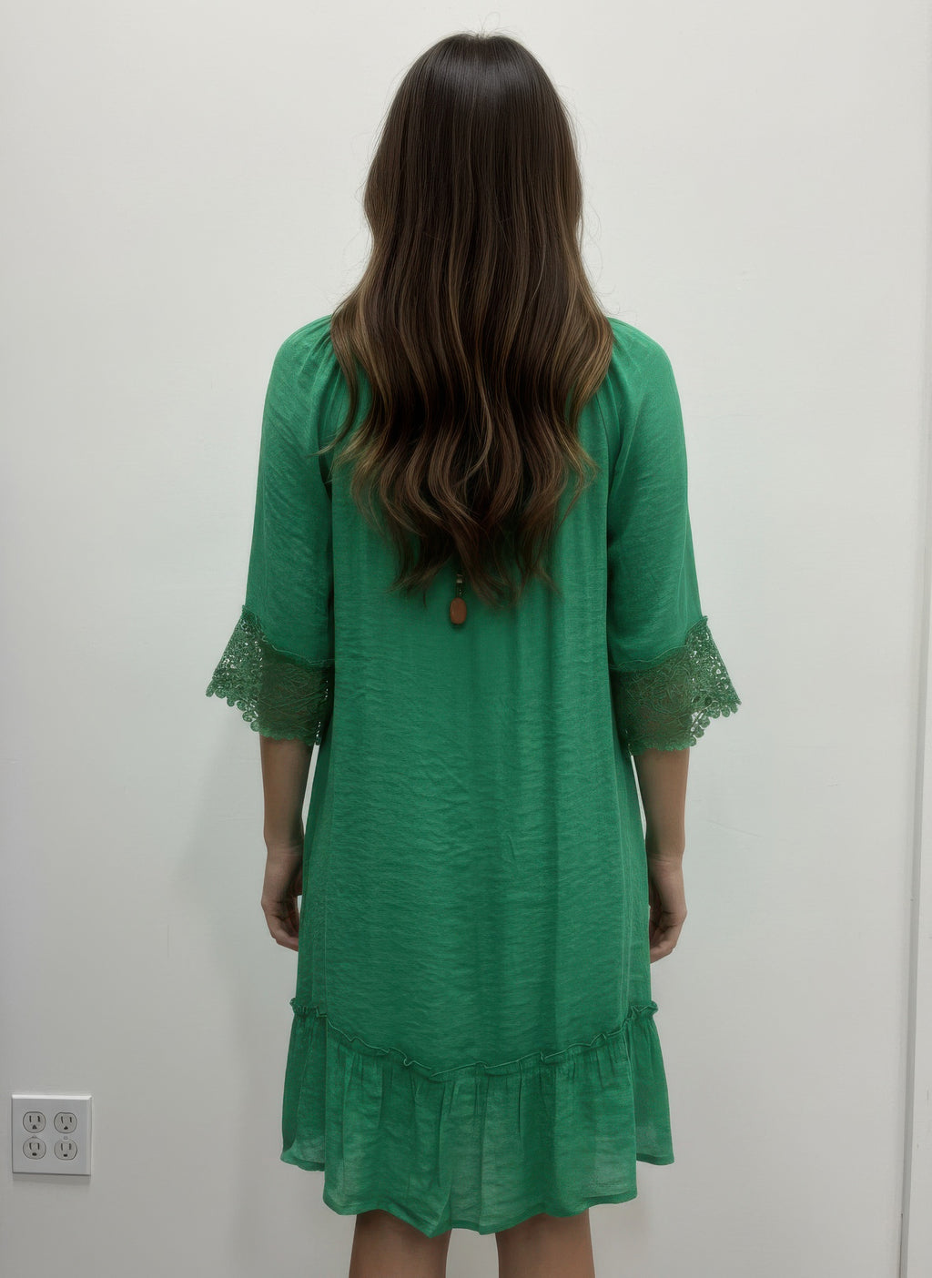Solid color green dress, back view with lace-trimmed elbow sleeves and tiered hem