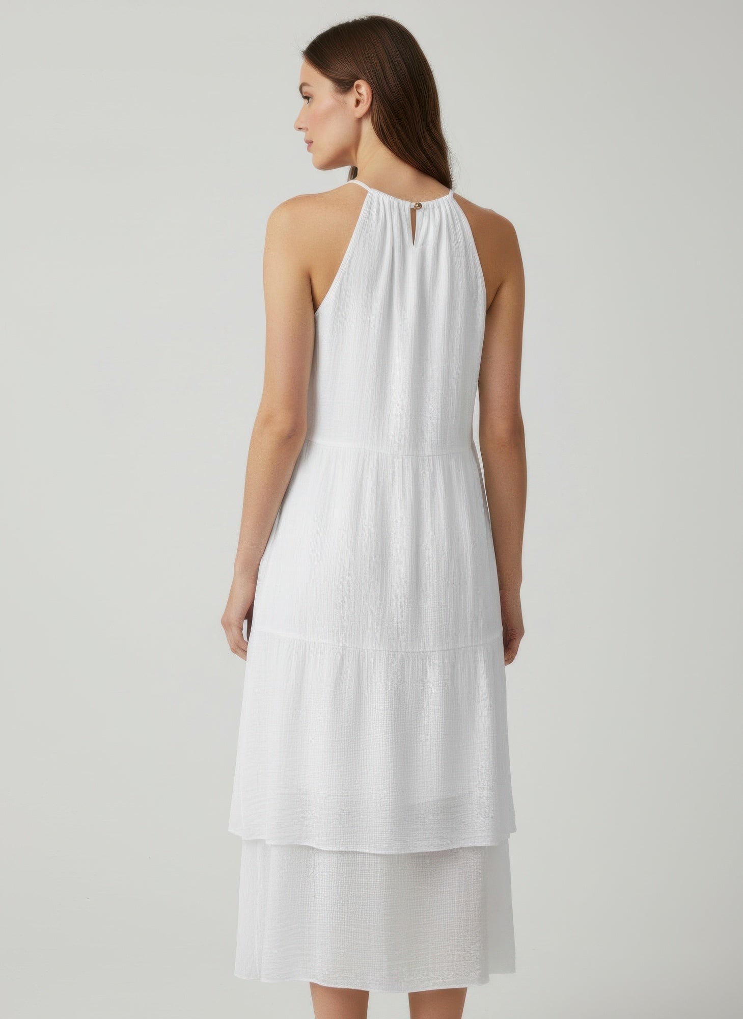 White sleeveless midi dress, back view, keyhole detail at halter neck, tiered hem
