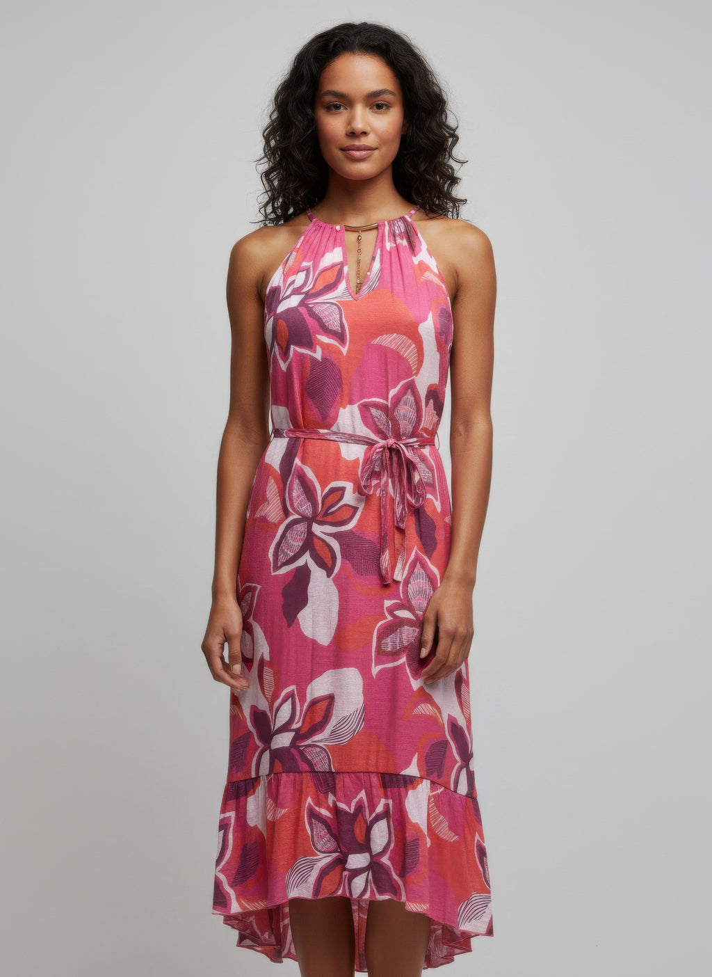 Floral dress in pink with halter neckline, tied waist, and ruffled hem