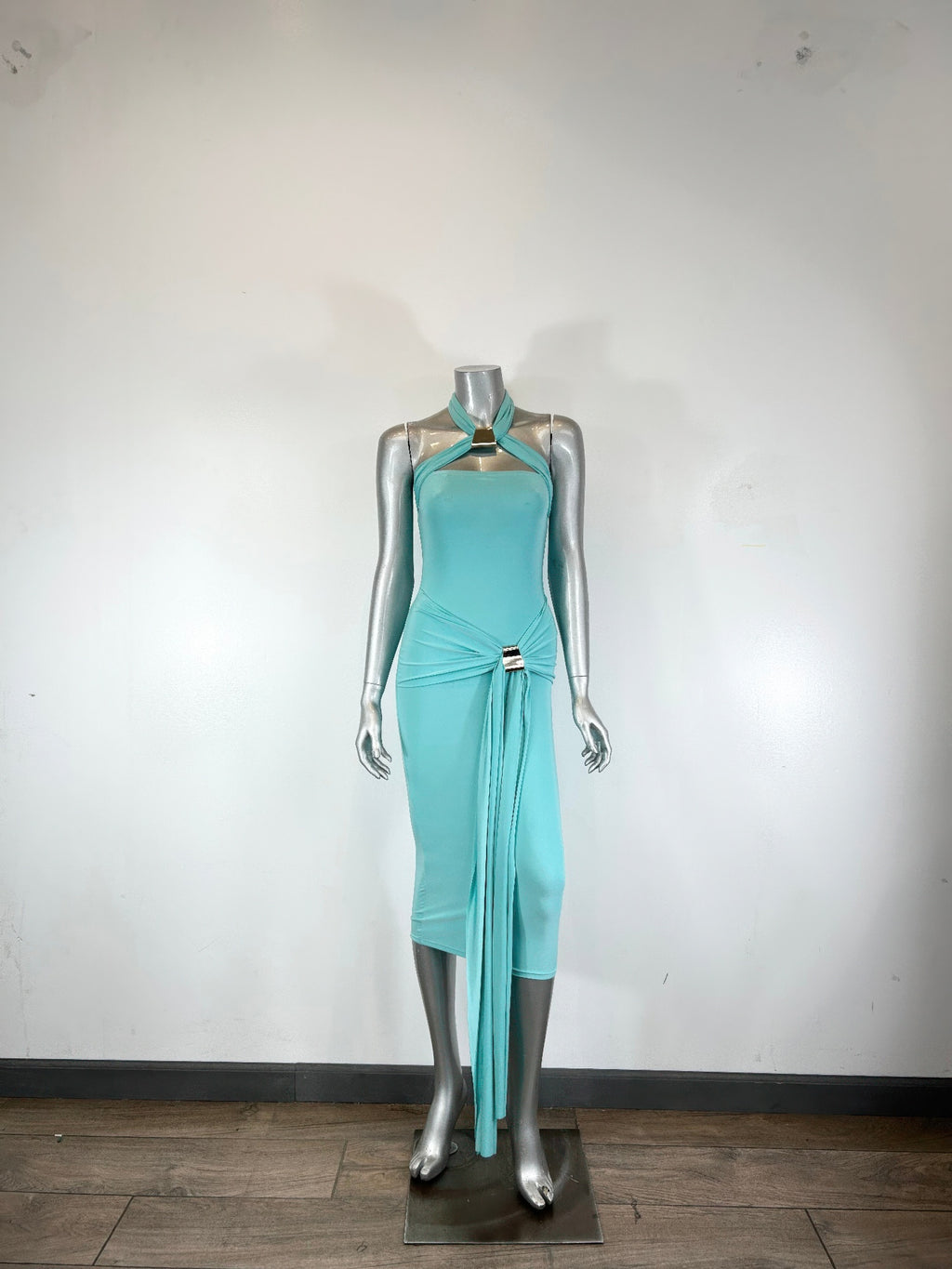 Aqua halter bodycon midi dress on mannequin, draped waist detail with metal accent