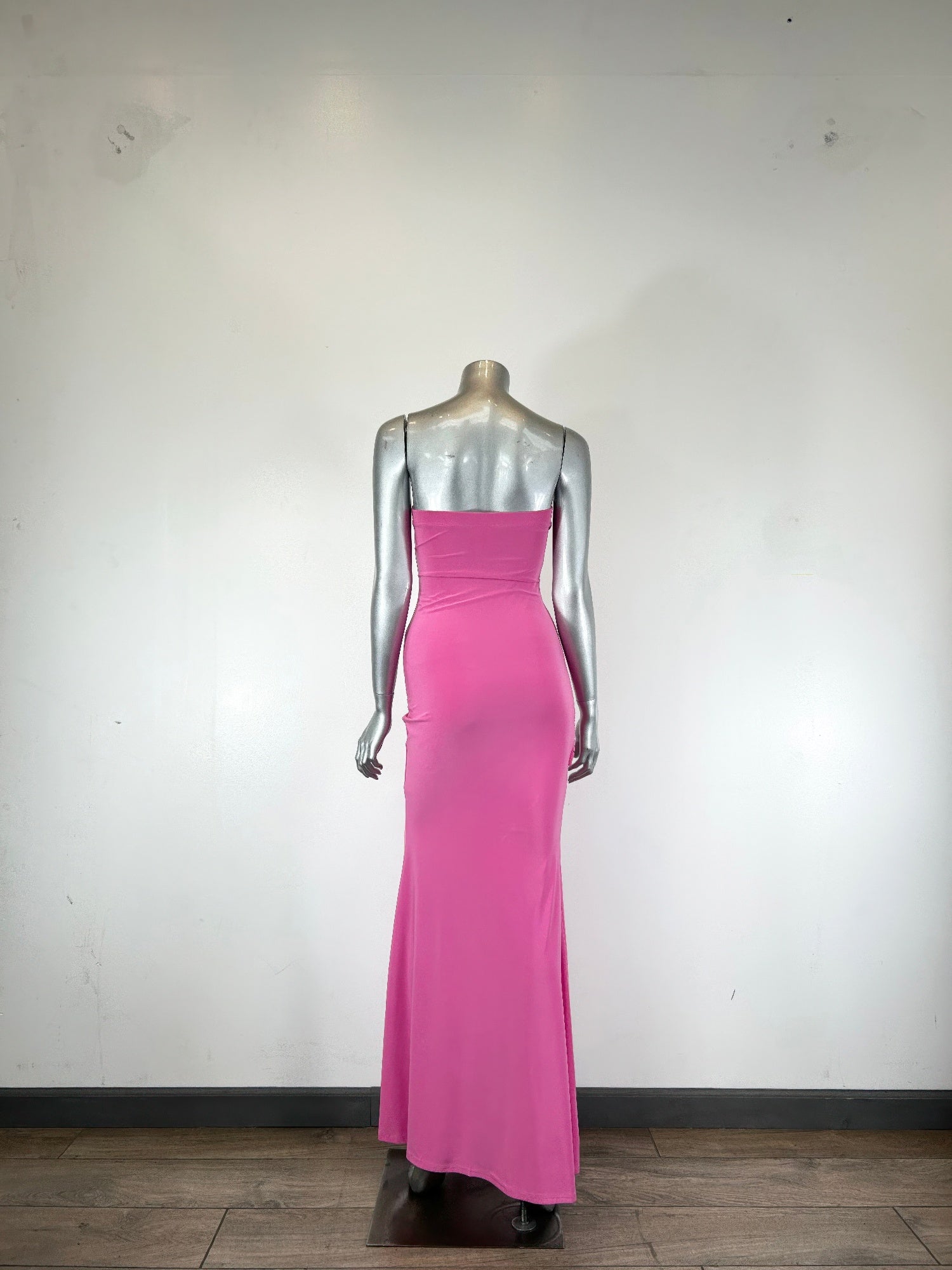 Back view of bubblegum pink strapless maxi dress, fitted with draped seams